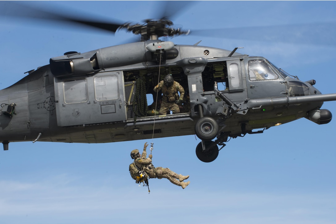 Airmen aboard an HH-60G Pave Hawk hoist a pararescueman up to the aircraft during a demonstration at Royal Air Force Lakenheath, England, April 21, 2016. The pararescueman is assigned to the 57th Rescue Squadron. Air Force photo by Staff Sgt. Emerson Nuñez