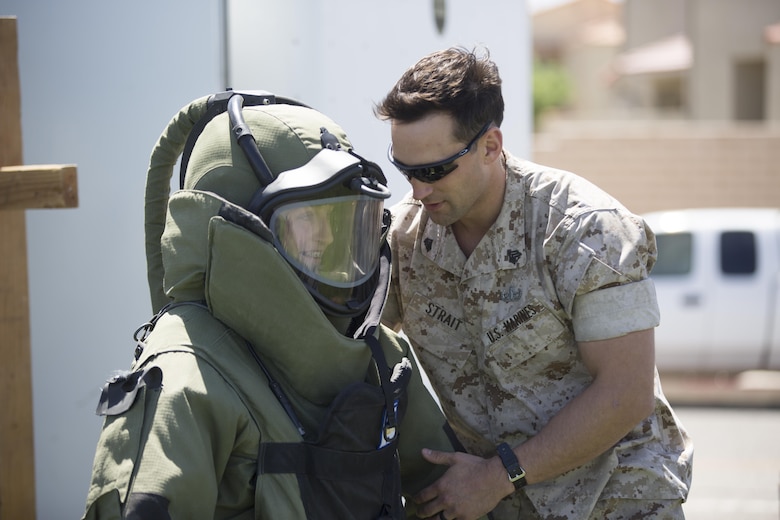 Sgt. Alexander Strait, Explosive Ordnance Disposal technician, EOD, helps Tatum Genovese, 14, try on a bomb disposal suit during the Twentynine Palms Car Show and Street Fair at Luckie Park in Twentynine Palms, Calif., April 16, 2016. (Official Marine Corps photo by Cpl. Julio McGraw/Released)