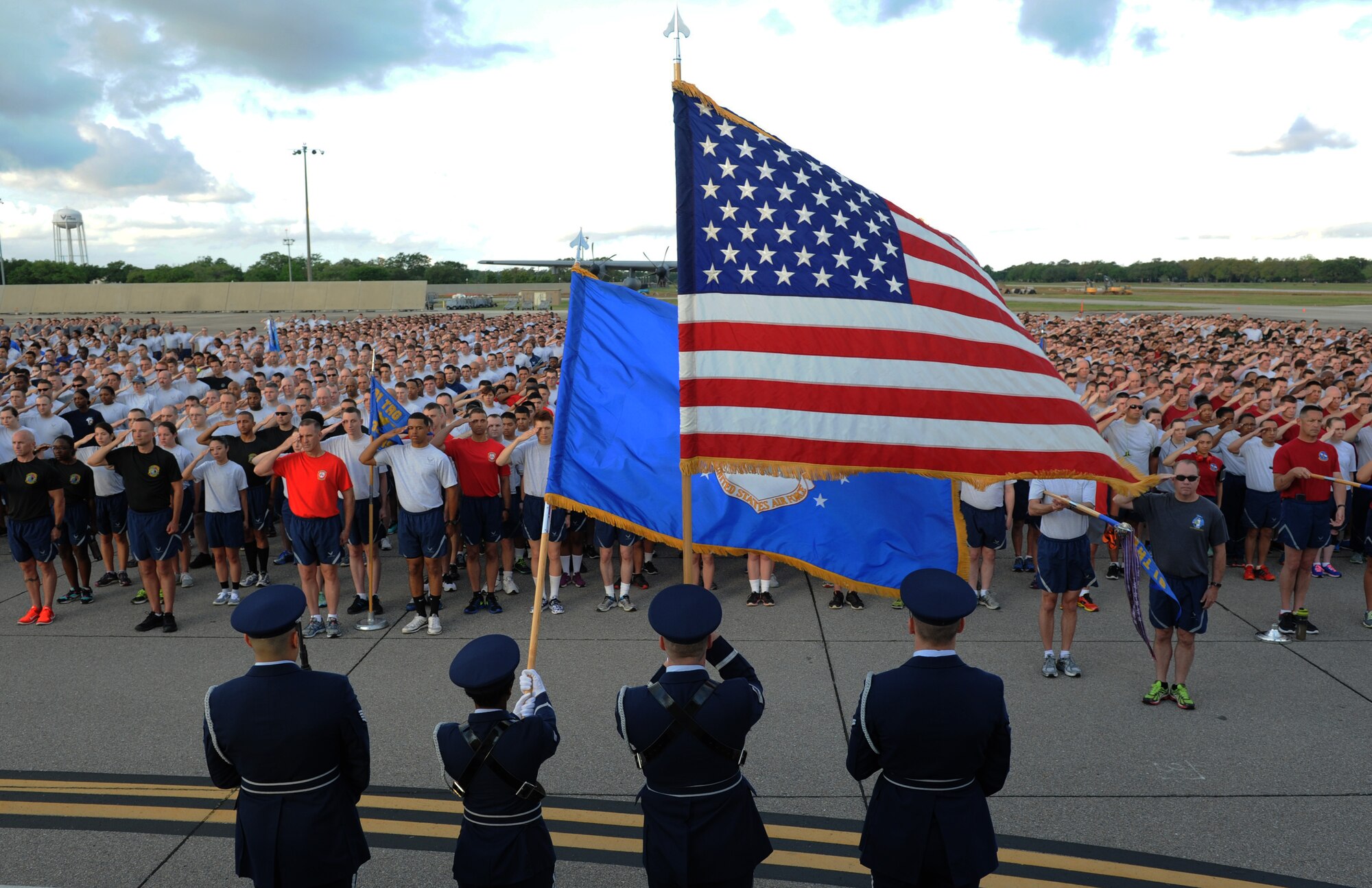 Keesler Airmen render a salute as the national anthem is sung prior to the start of a 5K run April 25, 2016, Keesler Air Force Base, Miss. The run was the kickoff event for a week full of activities supporting Wingman Week. (U.S. Air Force photo by Kemberly Groue)