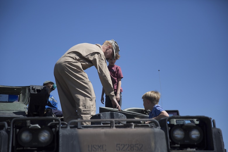 Lance Cpl. Chad Robbins, amphibious assualt vehicle crewman, 3rd Assault Amphibian Battalion, shows children the driver’s compartment of an AAV during the Twentynine Palms Car Show and Street Fair at Luckie Park in Twentynine Palms, Calif., April 16, 2016. (Official Marine Corps photo by Cpl. Julio McGraw/Released)