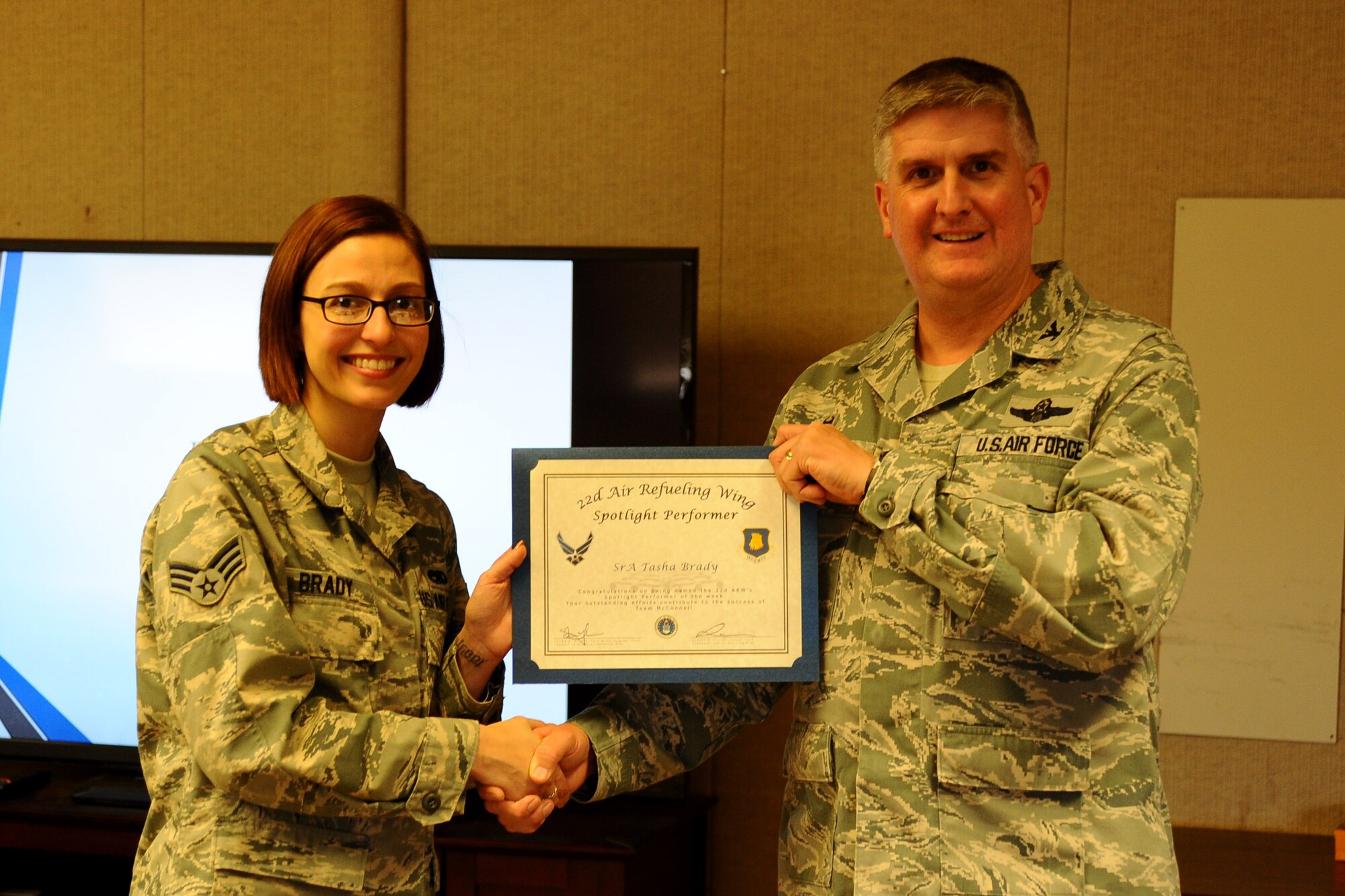 Senior Airman Tasha Brady, 22nd Air Refueling Wing community support coordinator administrator, poses with Col. Albert Miller, 22nd Air Refueling Wing commander, April 15, 2016, at McConnell Air Force Base, Kan. Brady received the spotlight performer for the week of March 28 - April 1. (U.S. Air Force photo/Airman 1st Class Christopher Thornbury)