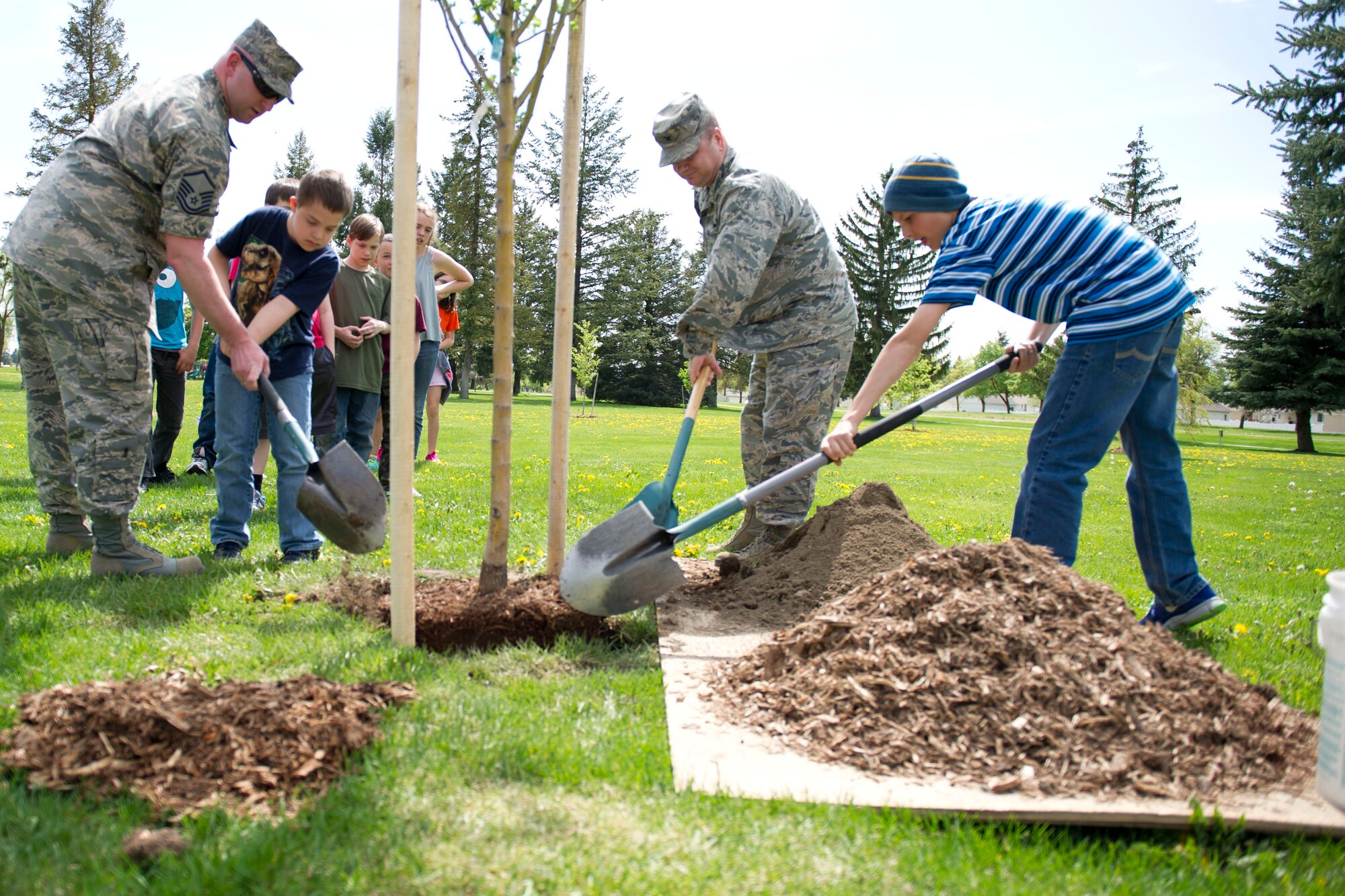 Children assist Air Force members with planting trees at the Miller Park Arboretum April 22, 2016, at Fairchild Air Force Base, Wash. Team Fairchild held a tree planting event in honor of Arbor Day. (U.S. Air Force photo/Airman 1st Class Sean Campbell)