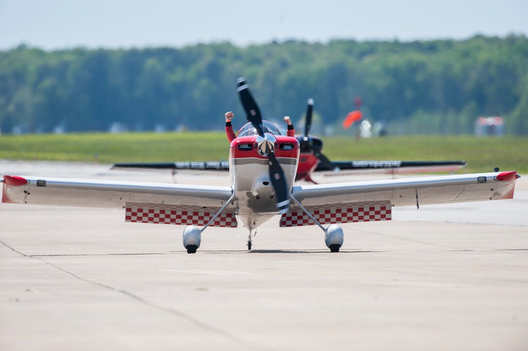 A RedLine AirShows performer cheers as he taxis in front of a crowd during the AirPower over Hampton Roads Open House at Langley Air Force Base, Va., April 24, 2016. RedLine Airshows is a two-ship team that performs opposing, inverted and formation maneuvers. (U.S. Air Force photo by Senior Airman Kayla Newman)