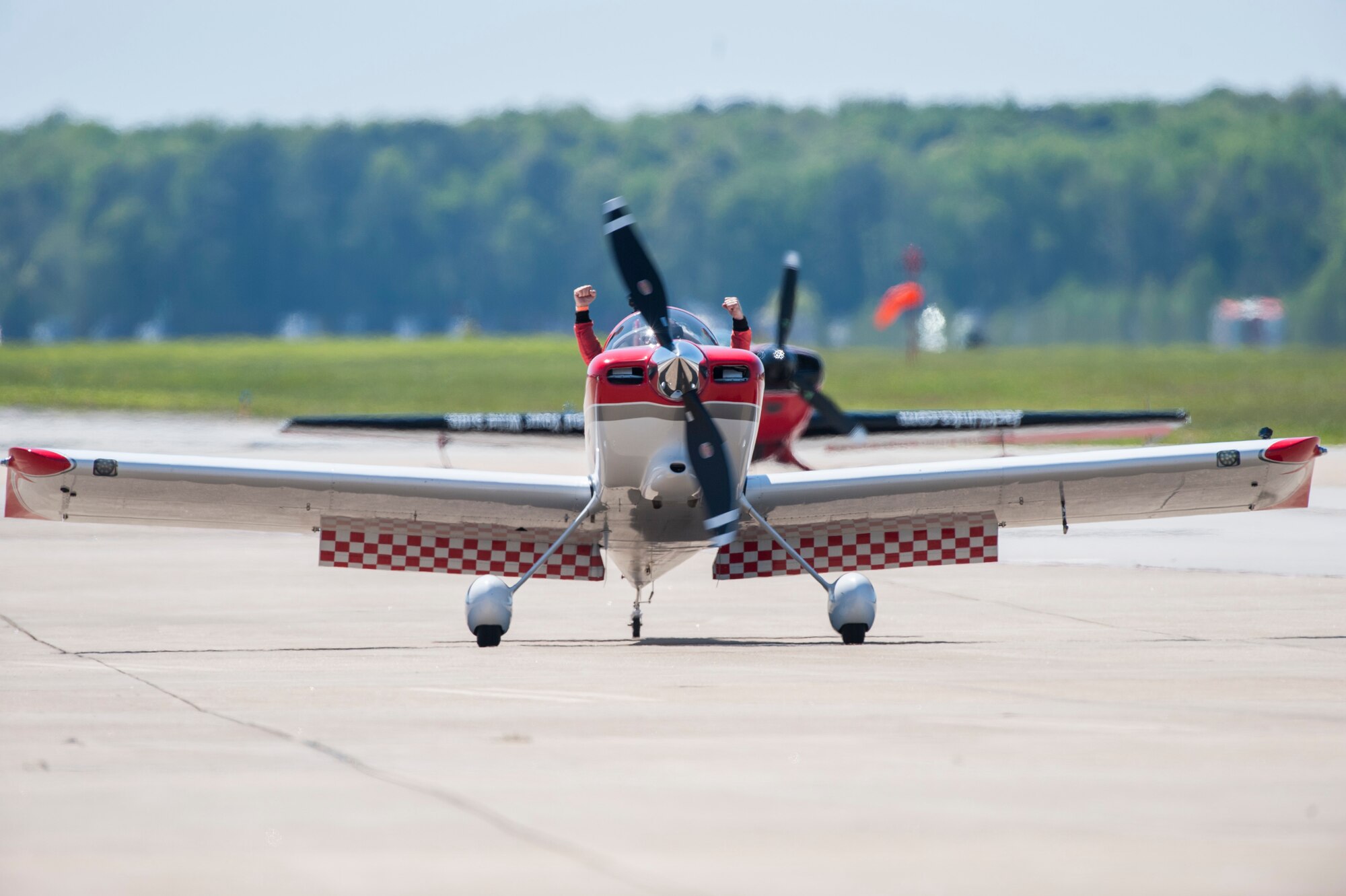 A RedLine AirShows performer cheers as he taxis in front of a crowd during the AirPower over Hampton Roads Open House at Langley Air Force Base, Va., April 24, 2016. RedLine Airshows is a two-ship team that performs opposing, inverted and formation maneuvers. (U.S. Air Force photo by Senior Airman Kayla Newman)