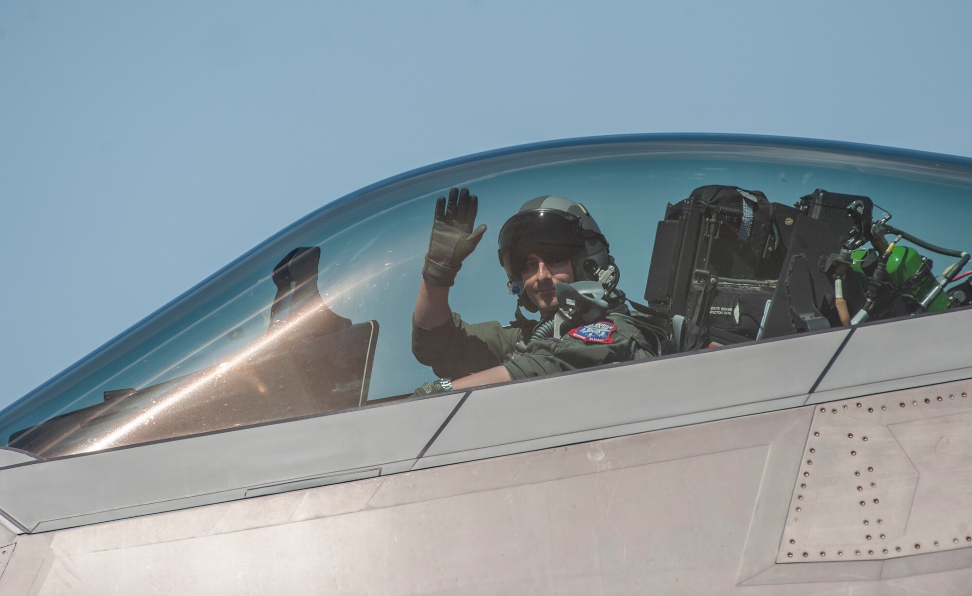 An F-22 Raptor pilot waves to a crowd at the AirPower over Hampton Roads Open House at Langley Air Force Base, Va., April 24, 2016. The Raptor performed its aerial demonstration prior to flying with the Heritage Flight during the Open House. (U.S. Air Force photo by Senior Airman Kayla Newman)