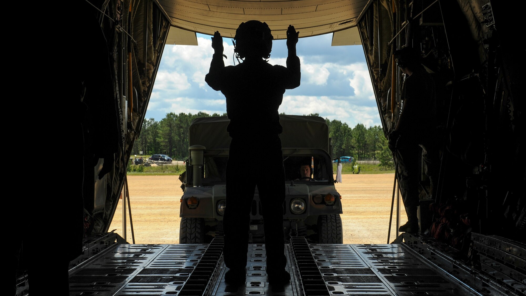 Royal Australian Air Force Sgt. Paul Cox, No. 37 Squadron C-130J loadmaster, directs a U.S. Air Force Humvee onto a C-130J April 22, 2016, at an improvised landing zone on Fort Polk, La. Australian forces worked alongside coalition forces from the U.S., Sweden, New Zealand and Australia during the Green Flag Little Rock 16-06 exercise. (U.S. Air Force photo/ Senior Airman Harry Brexel)  