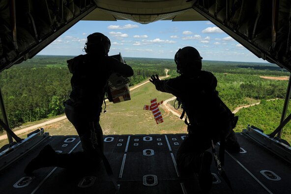 From left, Royal Australian Air Force Warrant Officer Ryan Bowden, and Royal Australian Air Force Sgt. Paul Cox, No. 37 Squadron C-130J loadmasters, drop two heliboxes from the back of a C-130J April 22, 2016, over Fort Polk, La. The Australian Airmen trained with U.S. Air Force Airmen from Little Rock Air Force Base, Ark., as part of Green Flag 16-06, a large-scale, joint mobility exercise. (U.S. Air Force photo/ Senior Airman Harry Brexel)  