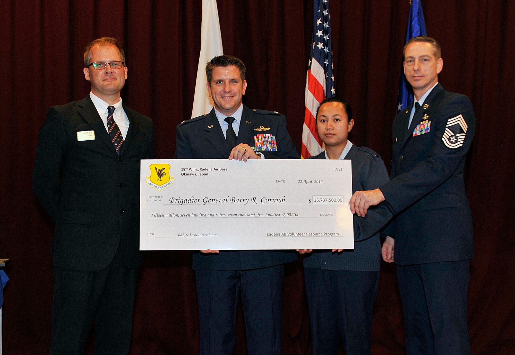 U.S. Air Force Col. Christopher Amrhein, 18th Wing vice commander, and Chief Master Sgt. Kenneth Boteler, 18th Operations Group superintendent, accept a symbolic check from the Kadena Volunteer Resource Program during the Annual Volunteer Recognition Ceremony at the Officer's Club, April 22, 2016, at Kadena Air Base, Japan. The $15,737,500 check represents how much volunteers would have earned if they were paid minimum wage for all of their volunteer hours. Over the past year, volunteers have contributed more than 682,000 hours of community service on and off base. (U.S. Air Force photo by Naoto Anazawa)