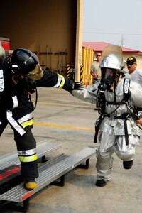 Honduran firefighter Jorge Betanco and Guatemalan Humanitarian Rescue Unit member Erick Osorio member hand off during a relay race during CENTAM SMOKE (Sharing Mutual Operational Knowledge and Experience), a biannual event hosted by Joint Task Force-Bravo at Soto Cano Air Base, Honduras, April 19, 2016. This iteration of CENTAM SMOKE included 34 firefighters participating in strenuous and challenging firefighting activities next to their U.S. counterparts.  During this iteration, the combined Central American team beat the U.S. team. (U.S. Army photo by Martin Chahin/Released)