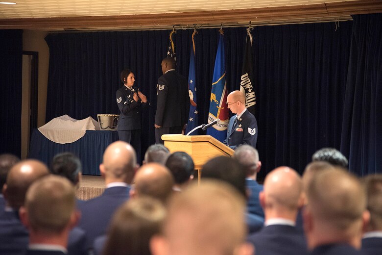 PETERSON AIR FORCE BASE, Colo.- Tech. Sgt. Megan Schmidt, 18th Cadet Squadron, U.S. Air Force Academy, Colorado, and Forrest L. Vosler Noncommissioned Officer Academy class leader and distinguished graduate, presents the American Flag during the class graduation at the Peterson Air Force Base Club April 12, 2016. Schmidt and 95 other students from 14 different bases and nine Major Commands attended and graduated Vosler NCOA’s first class through the new Intermediate Leadership Experience course. (U.S. Air Force photo by Staff. Sgt. Tiffany DeNault)