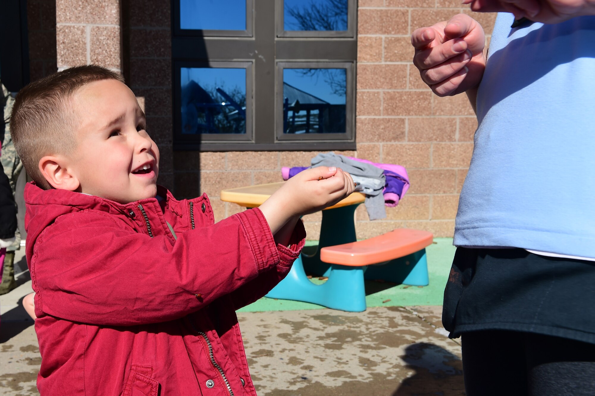 A boy from the Crested Butte Child Development Center holds open his hands that are filled with ladybugs April 22, 2016, on Buckley Air Force Base, Colo. To celebrate Earth Day, Buckley AFB held different activities that represented the bases commitment to healthy environmental practices. (U.S. Air Force photo by Airman 1st Class Luke W. Nowakowski/Released)