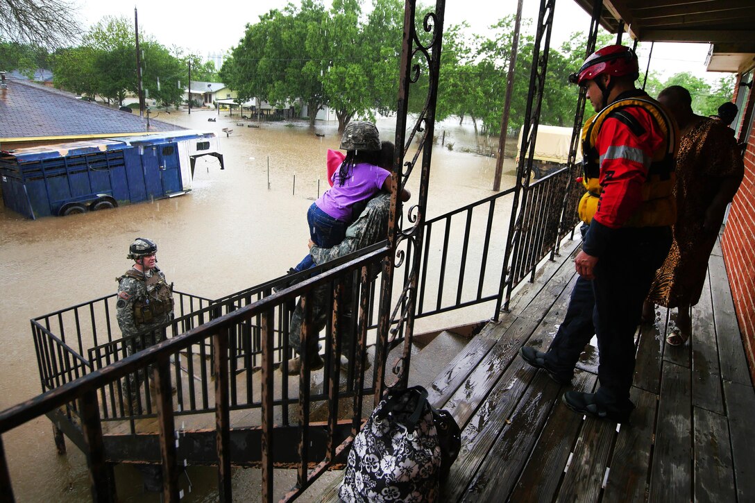 Soldiers and Texas Task Force 1 rescue personnel help stranded residents from their homes and load them into awaiting light multi-terrain vehicles during severe flooding in Wharton, Texas, April 21, 2016. Texas Army National Guard photo by 1st Lt. Zachary West