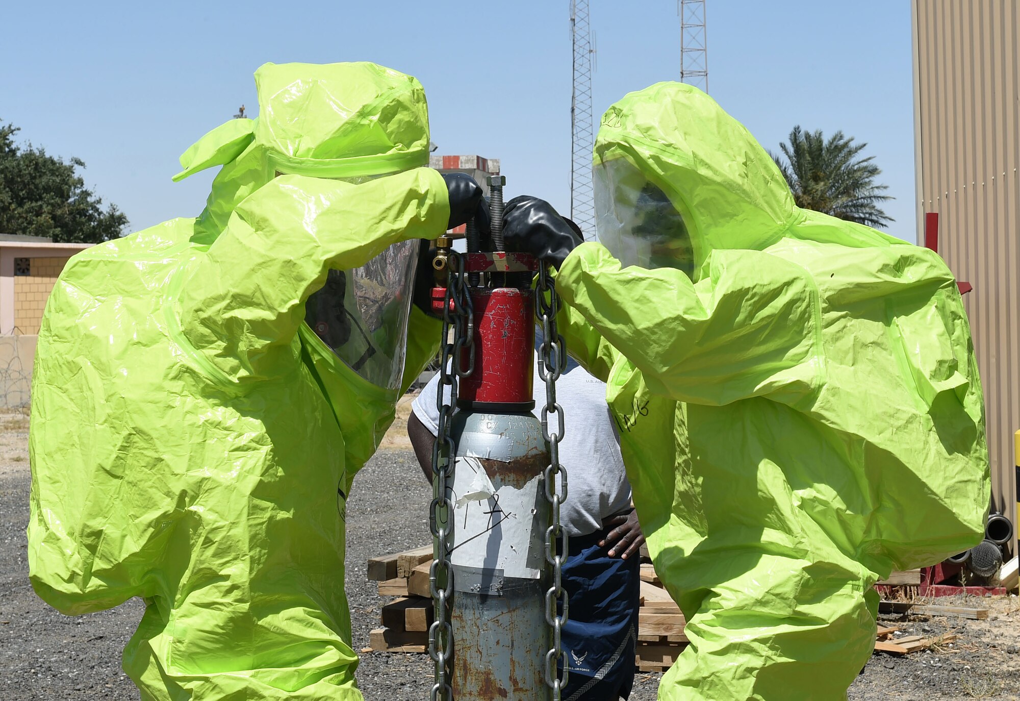 A firefighter from the 386th Expeditionary Civil Engineer Squadron and a firefighter from the 332nd ECES work to control a leaking valve on a simulated chlorine tank during a Hazardous Materials Technician Certification course exercise at an undisclosed location in Southwest Asia, April 15, 2016. The exercise simulated a chlorine gas leak to which the fire department, emergency management and medical teams from the 386th and 332nd ECES teams responded. (U.S. Air Force photo by Staff Sgt. Jerilyn Quintanilla)