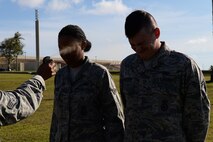 Airman Zakiya Dillahunt and Airman 1st Class Cody Schmouder, 36th Security Forces Squadron unit orientation training members, receive their oleoresin capsicum spray familiarization March 25, 2016, at Andersen Air Force Base, Guam. SFS Airmen receive a dose of the spray during training to experience just how effective OC spray is and that they only need to use it in small amounts. (U.S. Air Force photo by Airman 1st Class Jacob Skovo)