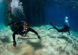 (April 15, 2016) Capt. Kyle Moses, commodore of Commander, Task Force (CTF) 56, left, and Explosive Ordnance Disposal Technician Master Chief Chris Borkenheim, command master chief of CTF 56, conducts pier inspections during International Mine Countermeasures Exercise (IMCMEX) 16, April 15, 2016. IMCMEX 16 is a multilateral exercise using all aspects of defensive maritime warfare including mine countermeasures, maritime security operations and maritime infrastructure protection to demonstrate the global resolve to maintain commerce throughout the U.S. 5th Fleet area of operations. 