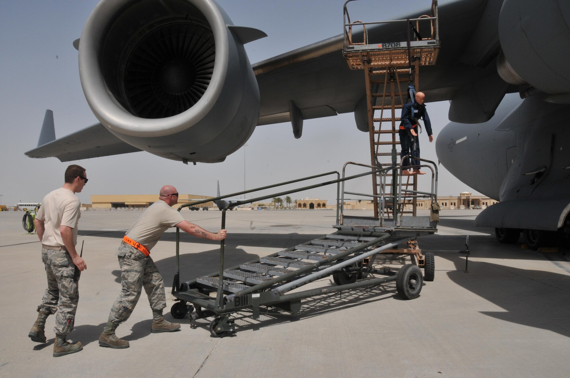 Staff Sgt. Steven Sentner (left) and Staff Sgt. Robert Hill(right), 8th Expeditionary Aircraft Maintenance Squadron crew chiefs, jump into action after seeing a “maintenance worker” suspended from a harness. The safe recovery of the fallen worker was tested, during a rescue exercise April 15 at Al Udeid Air Base, Qatar. (U.S. Air Force photo by Tech. Sgt. Terrica Y. Jones/Released)