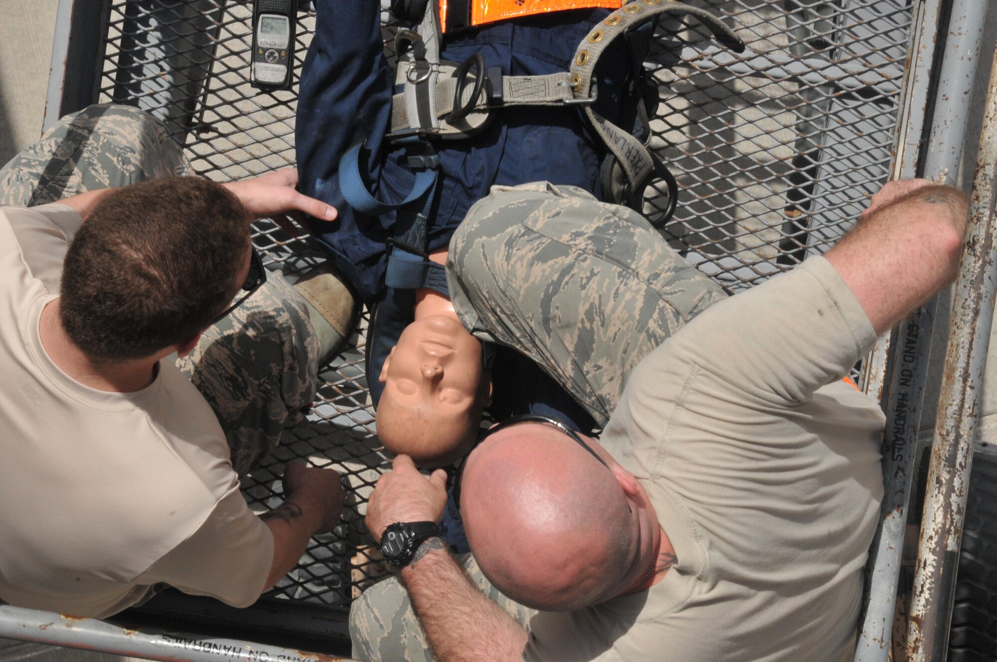 Staff Sgt. Steven Sentner (left) and Staff Sgt. Robert Hill (right), 8th Expeditionary Aircraft Maintenance Squadron crew chiefs, support a “maintenance worker” who fell from an aircraft during a rescue exercise April 15 at Al Udeid Air Base, Qatar. The Airmen assessed the worker for possible neck and other injuries until medical aid responders arrived. (U.S. Air Force photo by Tech. Sgt. Terrica Y. Jones/Released)