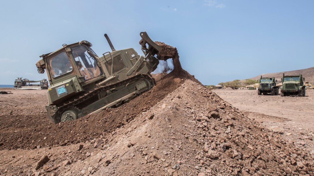 U.S. Marine Lance Cpl. Nicholas Bouvia, a heavy equipment operator with the 13th Marine Expeditionary Unit, builds a berm for security in Djibouti, Apr. 9, 2016. The 13th MEU is conducting sustainment training to maintain proficiency and combat readiness while deployed with the Boxer Amphibious Ready Group during Western Pacific Deployment 16-1. 