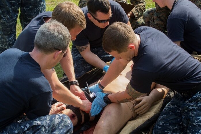 Sailors with 2nd Medical Battalion apply a tourniquet to the leg of a simulated wounded service member during a medical scenario at Camp Lejeune, N.C., April 20, 2016. The training exercise taught the sailors the basics of a Health Service Augmentation Program and allowed them to familiarize themselves with the gear they would find in a shock trauma platoon. The sailors, all medical personnel at the Camp Lejeune Naval Hospital, had to work together in a field environment and communicate all while bringing the same quality of healthcare found in the hospital.