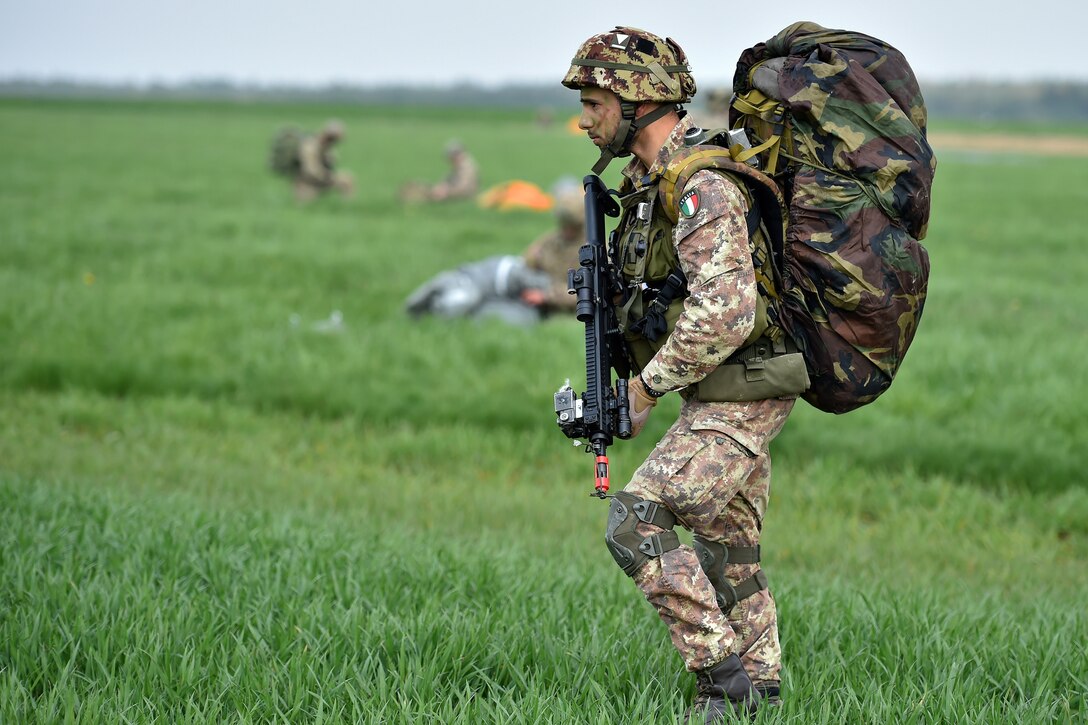 An Italian paratrooper walks to the rally point after participating in an airborne operation during exercise Saber Junction 16 near Hohenfels, Germany, April 12, 2016. Army photo by Gertrud Zach