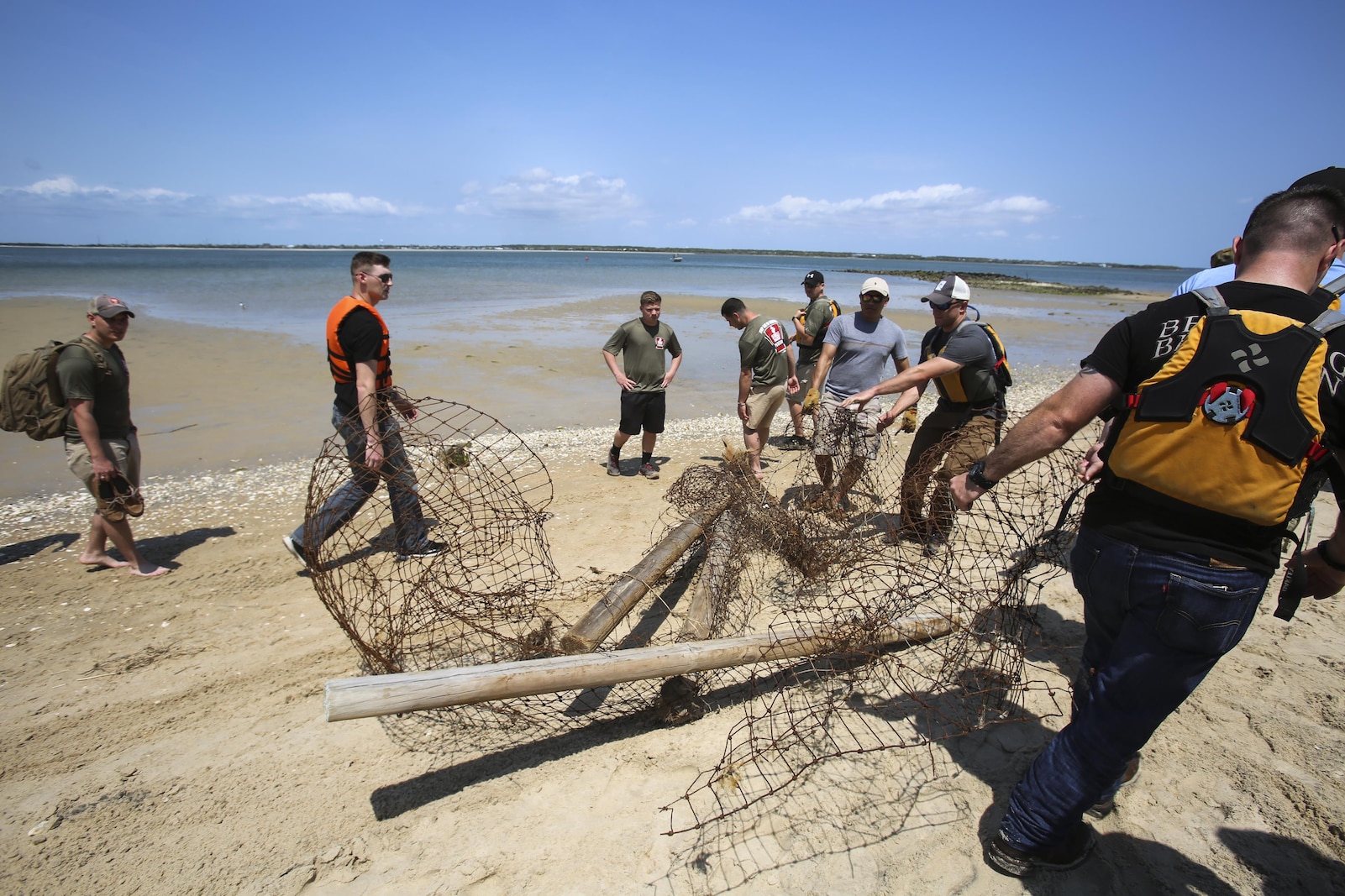 Clearing debris from the beach, Marines from 2nd Radio Battalion and 2nd Law Enforcement Battalion drag a fence to a ferry for removal as part of a beach clean-up of Shackleford Banks Island April 21, 2016. The Marines worked in cooperation with the Single Marine Program for transportation and the National Park service for removal of the trash. (U.S. Marine Corps photo by Lance Cpl. Miranda Faughn/Released)