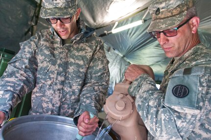 Sgt. Angel Burgos, left, and Staff Sgt. Dan Howard, right, both food service specialists with the 733rd Transportation Company, prepare ice tea during the annual Philip A. Connelly Award competition at Fort Indiantown Gap, Pa., April 23, 2016. (U.S. Army photo by Staff Sgt. Dalton Smith / Released)