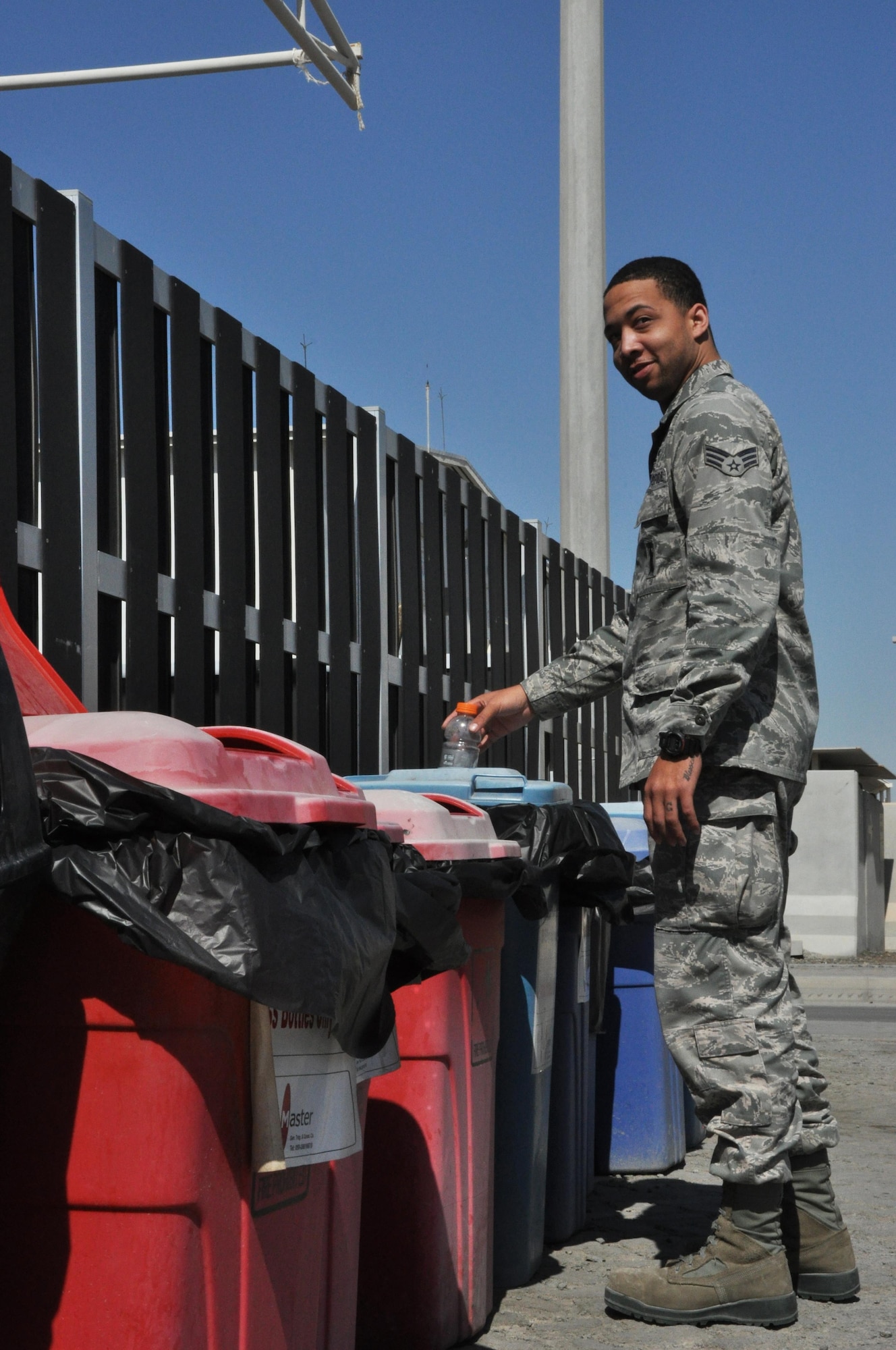 Senior Airman Devin, 380 Expeditionary Force Support Squadron Personnel Support for Contingency Operations technician, prepares to drop a plastic bottle into a blue recycling bin here in support of Earth Day, Apr. 22, 2016. Devin helped contribute to over 657 tons of material recycled here last year, saving the Air Force nearly $39,000. (U.S. Air Force photo by Staff Sgt. Samantha Mathison)