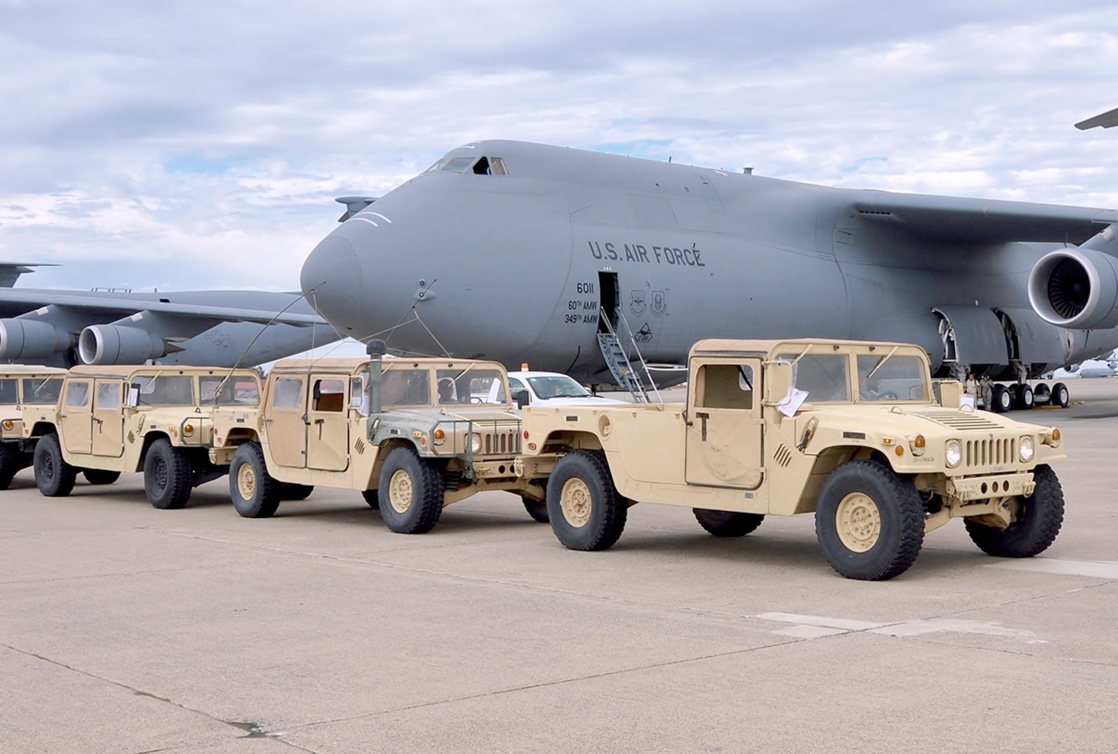Soldiers and Airmen prepare to load HMMWVs aboard C-5 for transport to Moffett Air Field during movement of HMMWVs and Soldiers from Travis Air Force Base in Fairfield, Calif., to Moffett Air Field in Sunnyvale, Calif., Aug. 4, 2015, during the Big Logistics-Over-The-Shore exercise, July 25-Aug. 7, 2015.