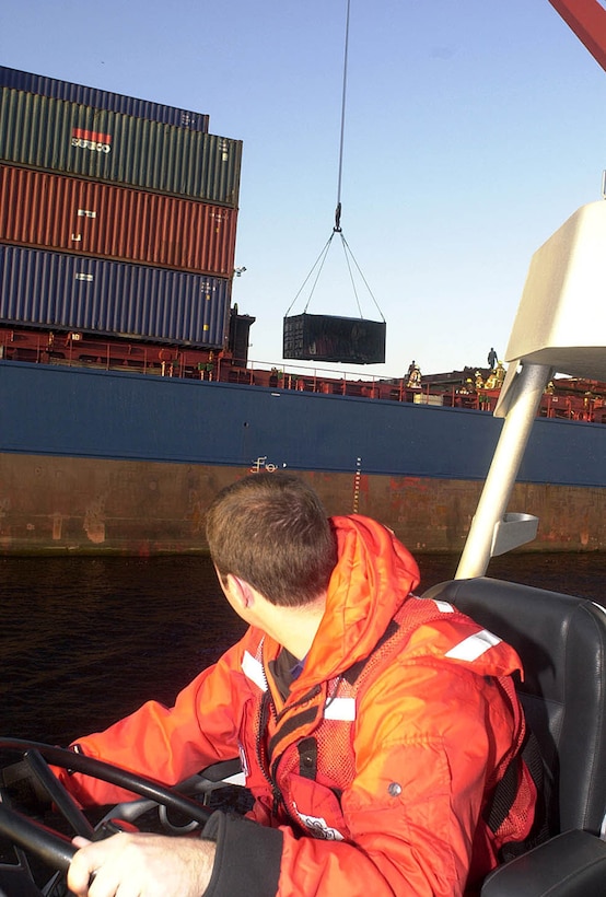 MAYPORT, Fla. (Jan. 21, 2003)--Petty Officer 3rd Class Robert Benne of Coast Guard Station Mayport, Fla., looks to the 486-foot container ship, Ara J, as crewmembers offload a damage container after a fire broke out in the ships cargo hold.  Station Mayport used three vessels to maintain a safety zone around the Ara J after the Captain of the Port shutdown the river for about two hours.  USCG photo by PA1 Scott Carr.