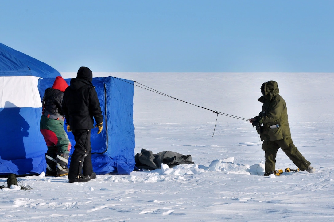 A Canadian military members and a U.S. airman set up camp at Little Cornwallis Island, Nunavut, Canada, April 6, 2016, in support of Canada's annual Operation Nunalivut. Airmen assigned to the New York Air National Guard's 109th Airlift Wing trained Canadian engineers how to prepare a ski-way for LC-130 Hercules operations and how to construct the ski-way. Canadian Rangers were also on-hand to provide perdator support. Air National Guard photo by Airman 1st Class Jamie Spaulding