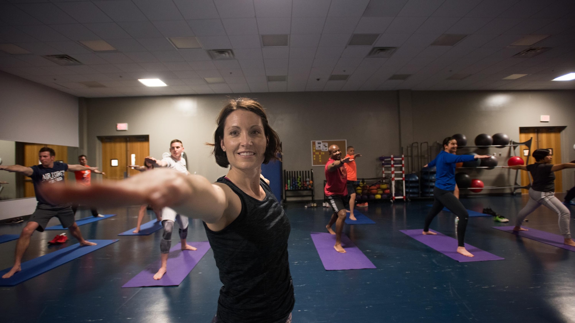 Lt. Col. Janelle Macaulay, the 305th Operations Support Squadron commander, leads members of her unit in a yoga class April 19, 2016, at the Falcon Fitness Center at Joint Base McGuire-Dix-Lakehurst, N.J. Yoga is one of several mental and physical fitness initiatives Macaulay and her leadership have implemented in the squadron. (U.S. Air Force photo/Staff Sgt. Katherine Tereyama)