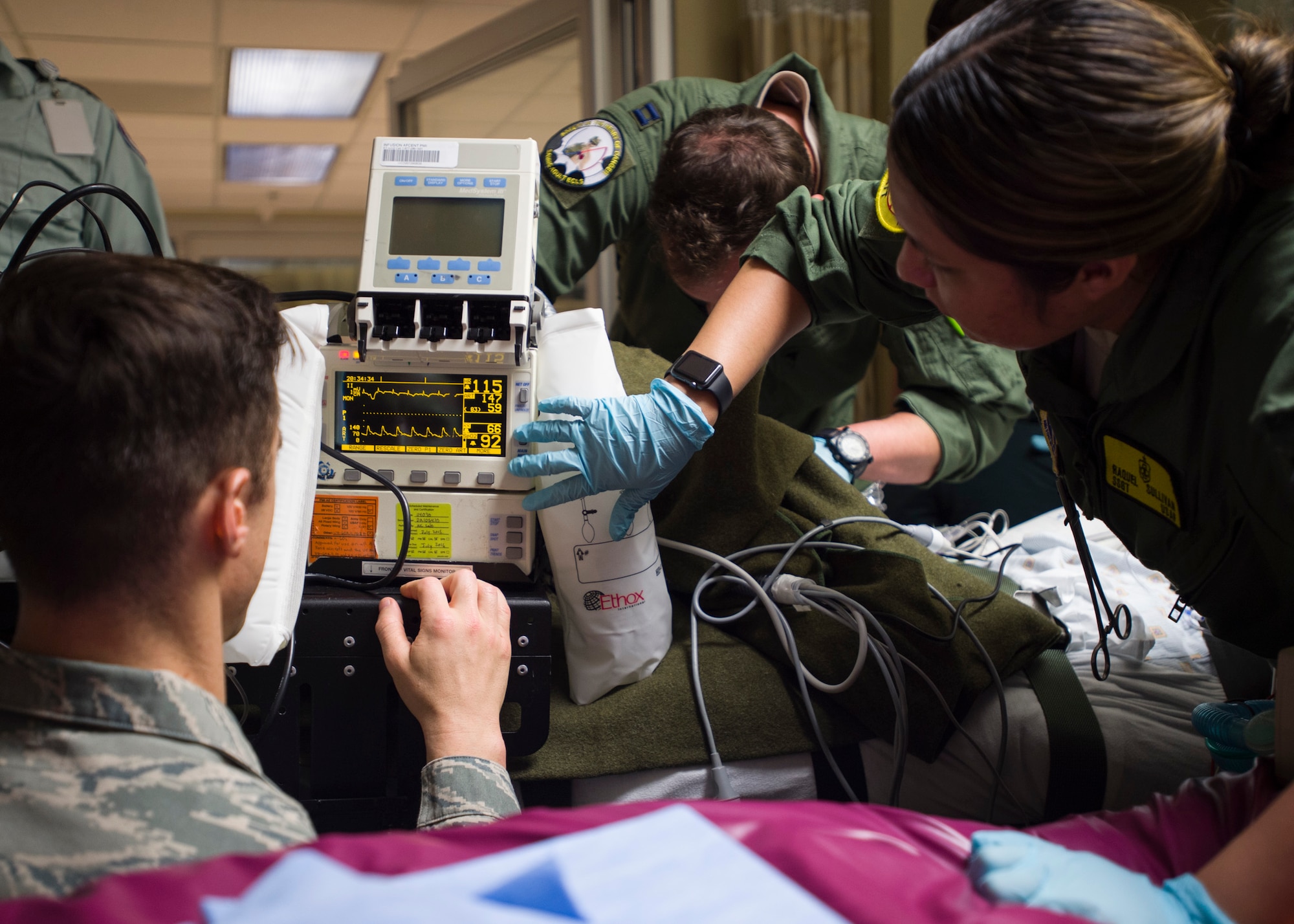 Members of the 59th Medical Wing Extracorporeal Membrane Oxygenation and Critical Care Air Transport Team adjust settings on a vital signs monitor at Lafayette General Medical Center April 20. The teams were preparing the patient for transport to San Antonio Military Medical Center, Joint Base San Antonio-Fort Sam Houston, Texas. (U.S. Air Force photo/Staff Sgt. Kevin Iinuma)