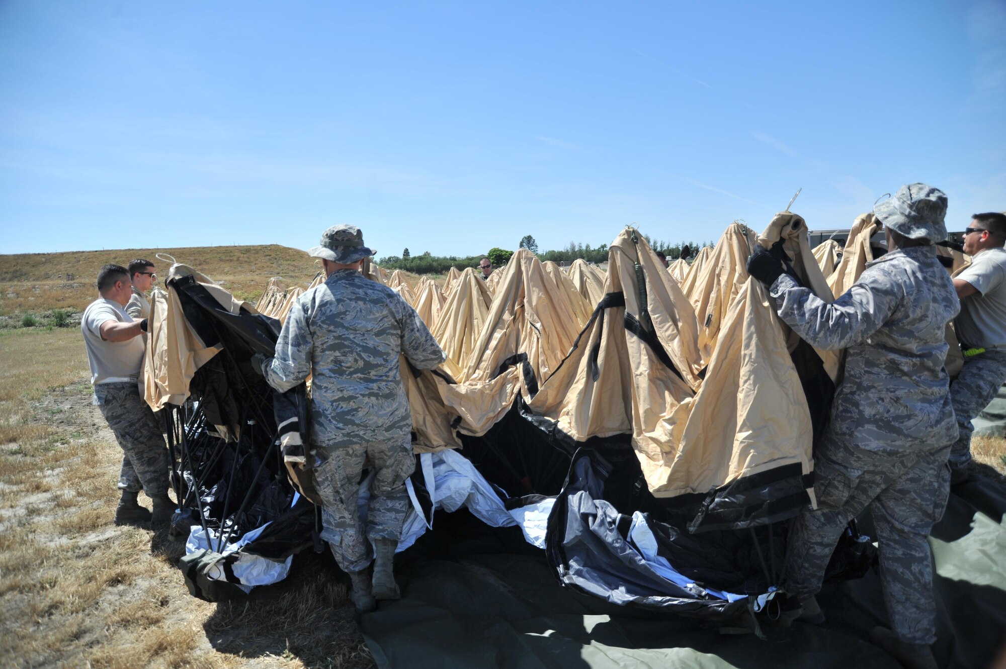 Airmen from the 433rd Airlift Wing, Joint Base San Antonio-Lackland, Texas begin erecting a Deployable Rapid Assembly Shelter tent, April 20, 2016 at Joint Forces Training Base, Los Alamitos, California.  A DRASH tent is a quick-erect tent system that integrates shelter, mobility, lighting, heating, cooling and energy efficient was used during the Air Force Reserve Command’s Patriot Hook exercise. (U.S. Air Force photo by Senior Airman Steven A. Ortiz/Released)