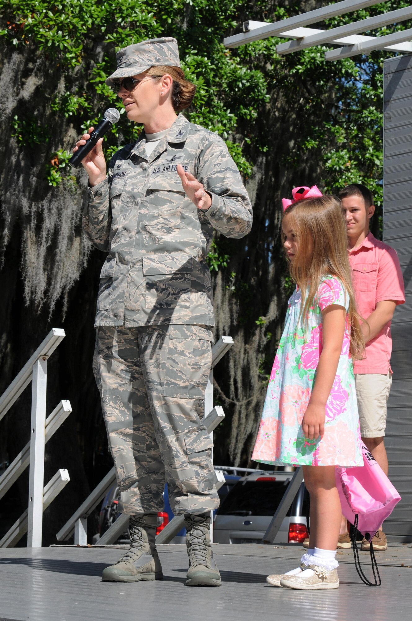 Col. Michele Edmondson, 81st Training Wing commander, delivers opening remarks with her daughter, Jacqueline McGowan, during Child Pride Day at marina park April 23, 2016, Keesler Air Force Base, Miss. Keesler families attended the annual event which featured activities, demonstrations and information on programs focused on care of military families. Child Pride Day was held in conjunction with the month of the military child. (U.S. Air Force photo by Kemberly Groue)