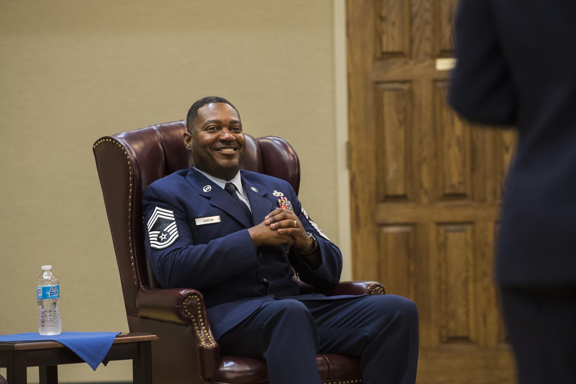 U.S. Air Force Chief Master Sgt. Will Hardin Jr. laughs as the officiator, Col. Yvonne Spencer, 819th Red Horse Squadron commander, gives her remarks, April 22, 2016, at Moody Air Force Base, Ga. Spencer, who previously served with Hardin, spoke about Hardin’s legacy and his affect on every Airman he encountered. (U.S. Air Force photo by Airman Daniel Snider/Released)