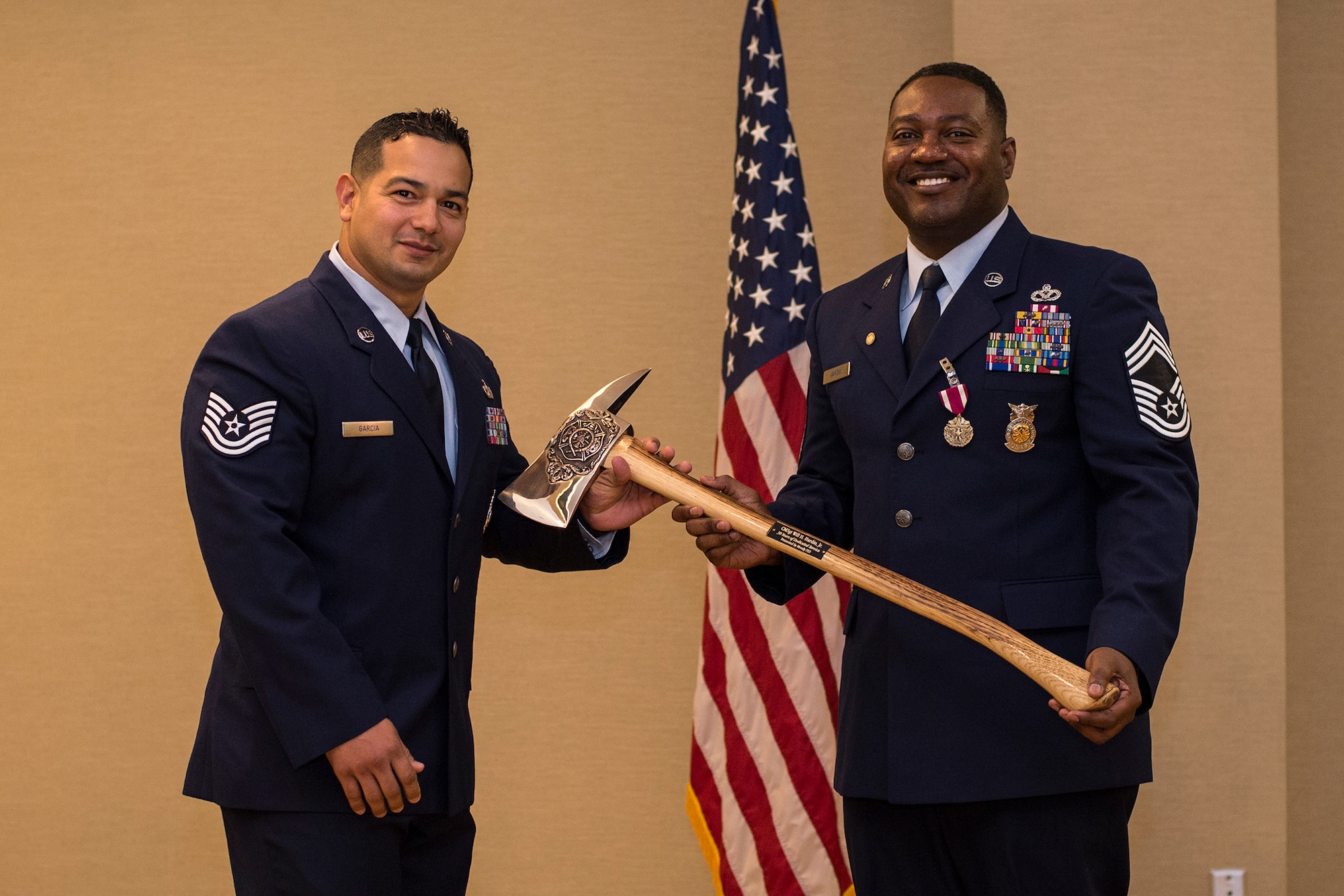 U.S. Air Force Tech. Sgt. Lionel Garcia, 23d Civil Engineer Squadron NCO in charge of health and safety, presents Chief Master Sgt. Will Hardin Jr. with a memento, April 22, 2016, at Moody Air Force Base, Ga. Hardin directed 69 firefighters who mitigated 636 emergencies and one major airplane crash while supporting two wings during his time at Moody. (U.S. Air Force photo by Airman Daniel Snider/Released)
