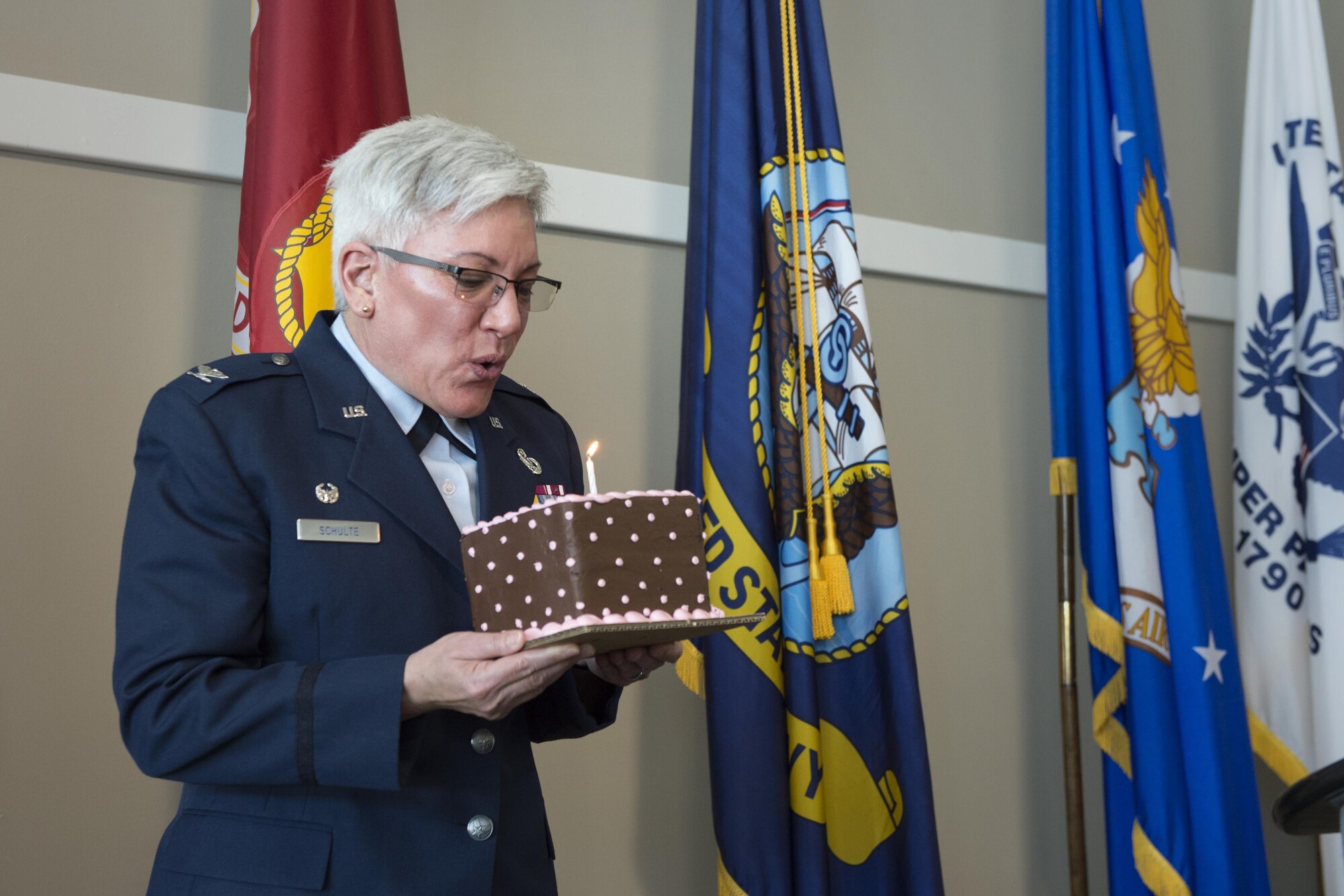 Col. Anna Schulte, 434th Maintenance Group commander, blows out a candle on her birthday cake during the Indiana Woman Veterans’ Conference in Indianapolis, April 15, 2016. Schulte was the key-note speaker for the event that fell on her birthday.  (U.S. Air Force photo/Tech. Sgt. Benjamin Mota)