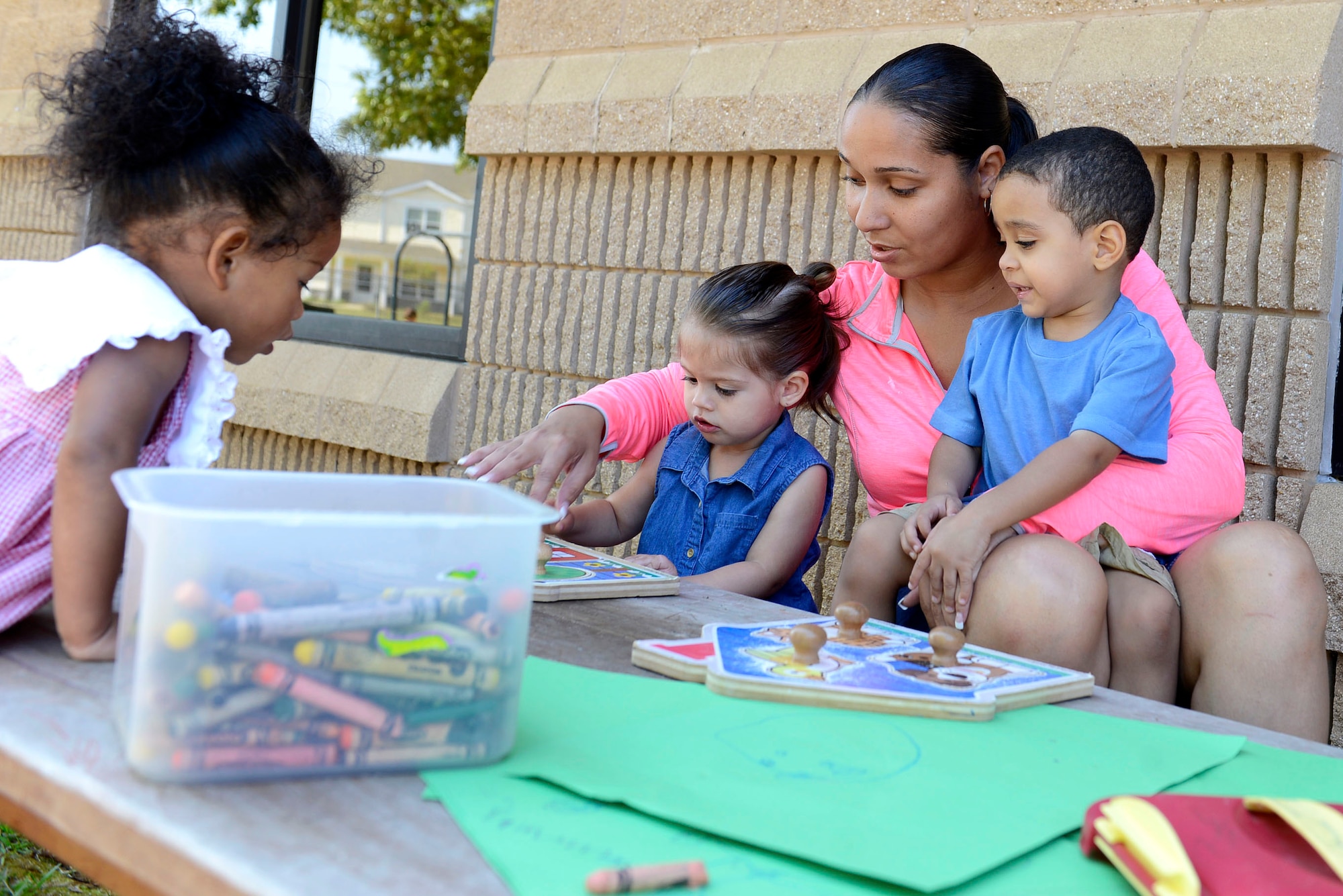 Latonya Calvin, 20th Force Support Squadron Child and Youth Program assistant, plays with children at the Chandler Cornell Child Development Center play yard at Shaw Air Force Base, S.C., April 26, 2016. The CDC provides a variety of age-appropriate programs for children ages 6 weeks to 5 years while their guardians are completing their respective missions. (U.S. Air Force photo by Airman 1st Class Christopher Maldonado)