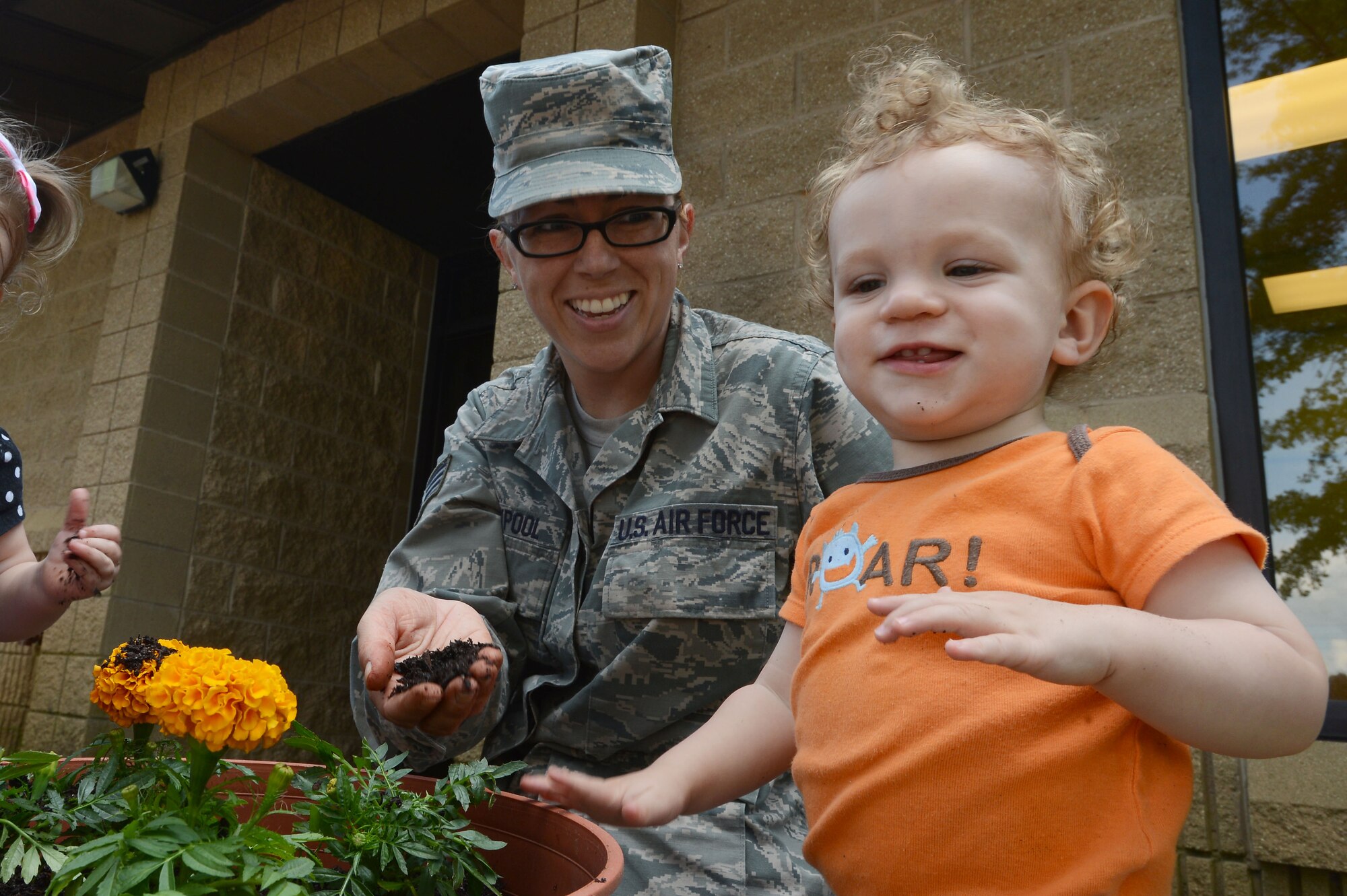 U.S. Air Force Staff Sgt. Laura Claypool, 20th Fighter Wing Public Affairs photojournalist and president of the 20th Force Support Squadron’s Child and Youth Services Parent Advisory Committee, plants flowers with her son, Lucas, on the Chandler Cornell Child Development Center playground in honor of Earth Day at Shaw Air Force Base, S.C., April 25, 2016. The PAC donated flowers, soil and other gardening supplies to the CDC to foster an appreciation for nature in the children. (U.S. Air Force photo by Senior Airman Zade Vadnais)