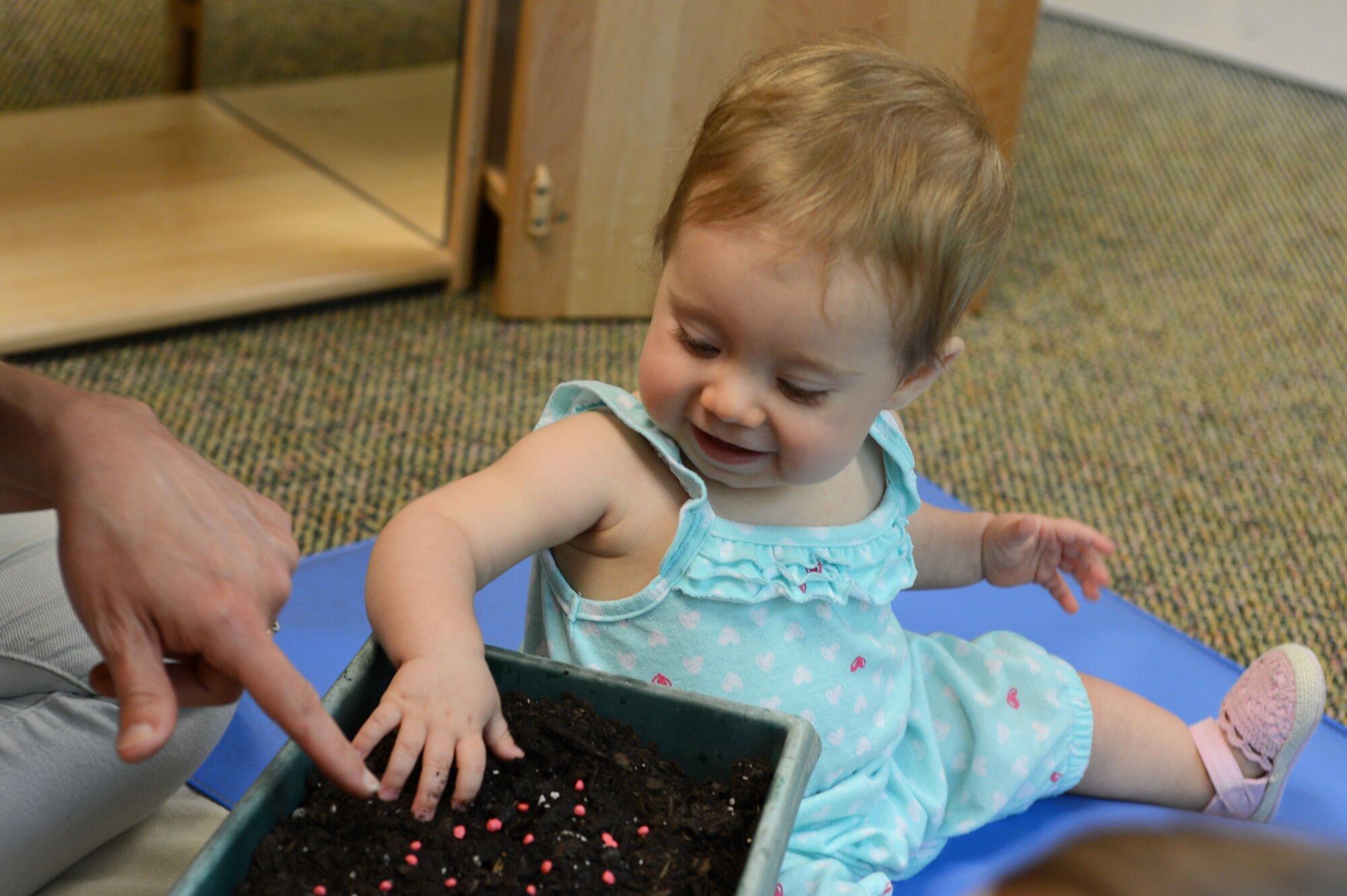 A Team Shaw child pushes seeds into potting soil on Earth Day at the Chandler Cornell Child Development Center at Shaw Air Force Base, S.C., April 22, 2016. Earth Day, which has been observed in the U.S. since 1970, is an annual event created to celebrate the planet and raise public awareness about environmental issues. (U.S. Air Force photo by Senior Airman Zade Vadnais) 