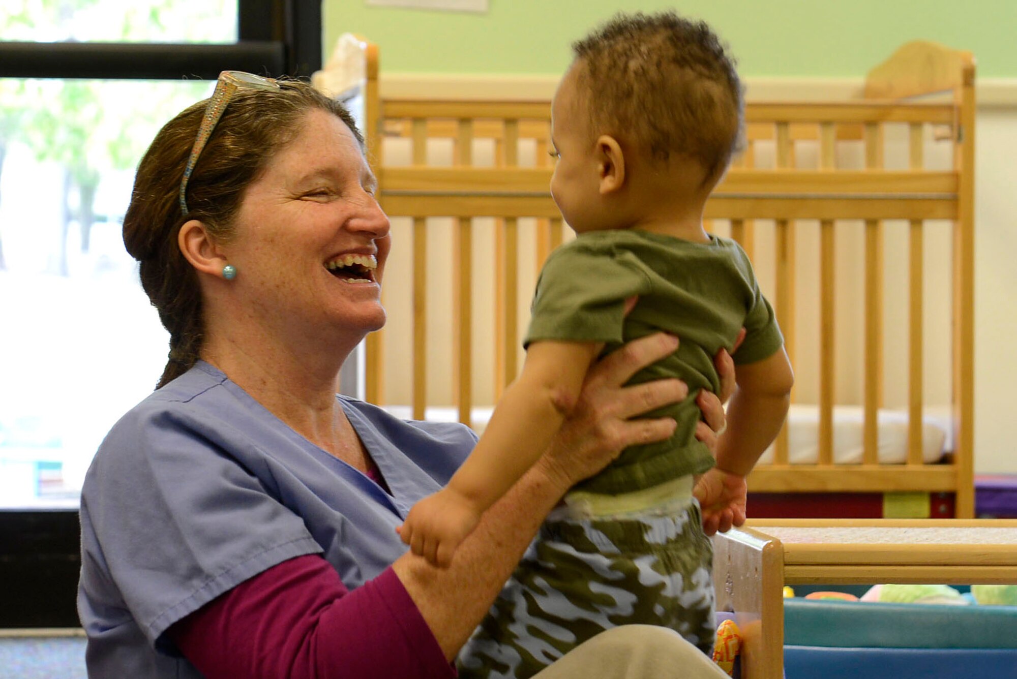 A 20th Force Support Squadron Child and Youth Services instructor holds a toddler during a Month of the Military Child spirit week at the 20th FSS Chandler Cornell Child Development Center at Shaw Air Force Base, S.C., April 16, 2016. Throughout the month of April, the Department of Defense Education Activity encouraged schools to plan events that recognize and show appreciation for our military children. 