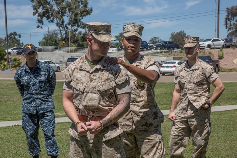 U.S. Marine Corps Staff Sgt. Leo Briggs, a corrections officer with Naval Consolidated Brig Miramar, and a Beaumont, Texas, native, demonstrates how to apply restraints during a Basic Brig Escort course aboard Marine Corps Air Station Miramar, Calif., April 19. The instructors with Naval Consolidated Brig Miramar certified 60 service members as basic escorts which will enable them to conduct prisoner escorts aboard MCAS Miramar and Marine Corps Base Camp Pendleton.  (U.S. Marine Corps photo by Sgt. Lillian Stephens/Released)