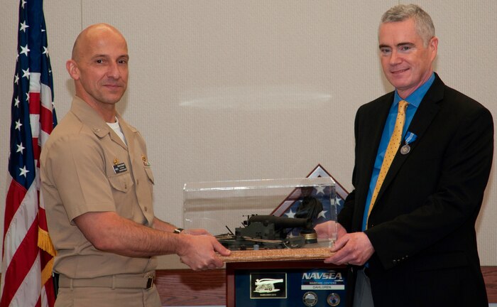 DAHLGREN, Va. - Naval Surface Warfare Center Dahlgren Division (NSWCDD) Commanding Officer Capt. Brian Durant presents the Dahlgren Award to NSWCDD Deputy Technical Director Dohn Burnett for 34 years of continuous service in March 2016. Burnett - who was also awarded the Navy Superior Civilian Service Medal at his retirement ceremony – considers leadership development as one of the top highlights of his civil service career. "Their (NSWCDD leaders at all levels) work is going to continue after the systems I helped develop are gone," said Burnett. "I made it a priority in my career to work on developing leaders and, in turn, they will develop leaders. That legacy will live on and Dahlgren will continue to do great work because it has good leaders."