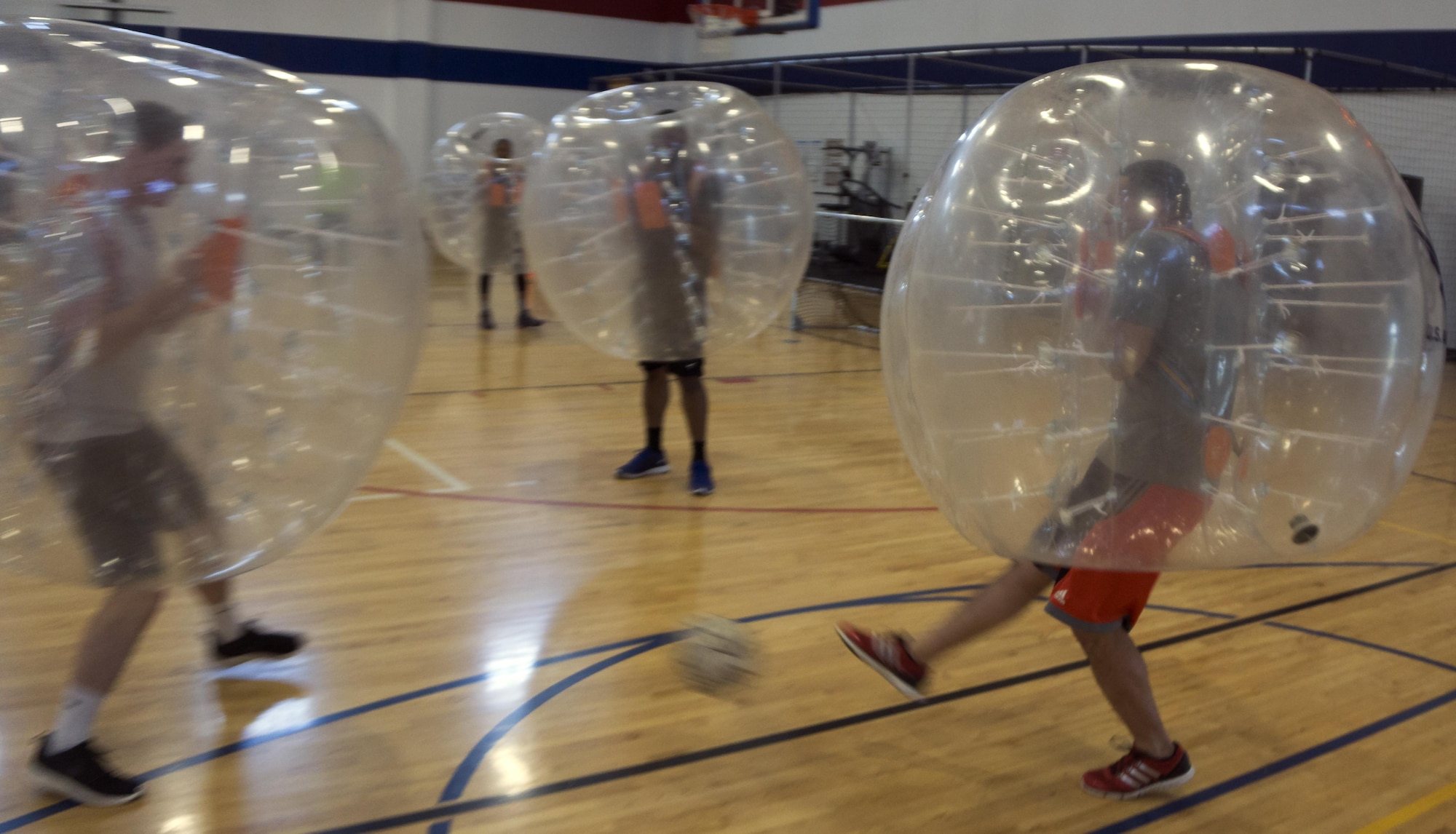 An Airman attempts to kick a soccer ball past a defender April 22, 2016, during a bubble soccer game in the Freedom Hall Fitness Center on F.E. Warren Air Force Base, Wyo. Six Teams competed in 5-minute games. (U.S. Air Force photo by Senior Airman Brandon Valle)