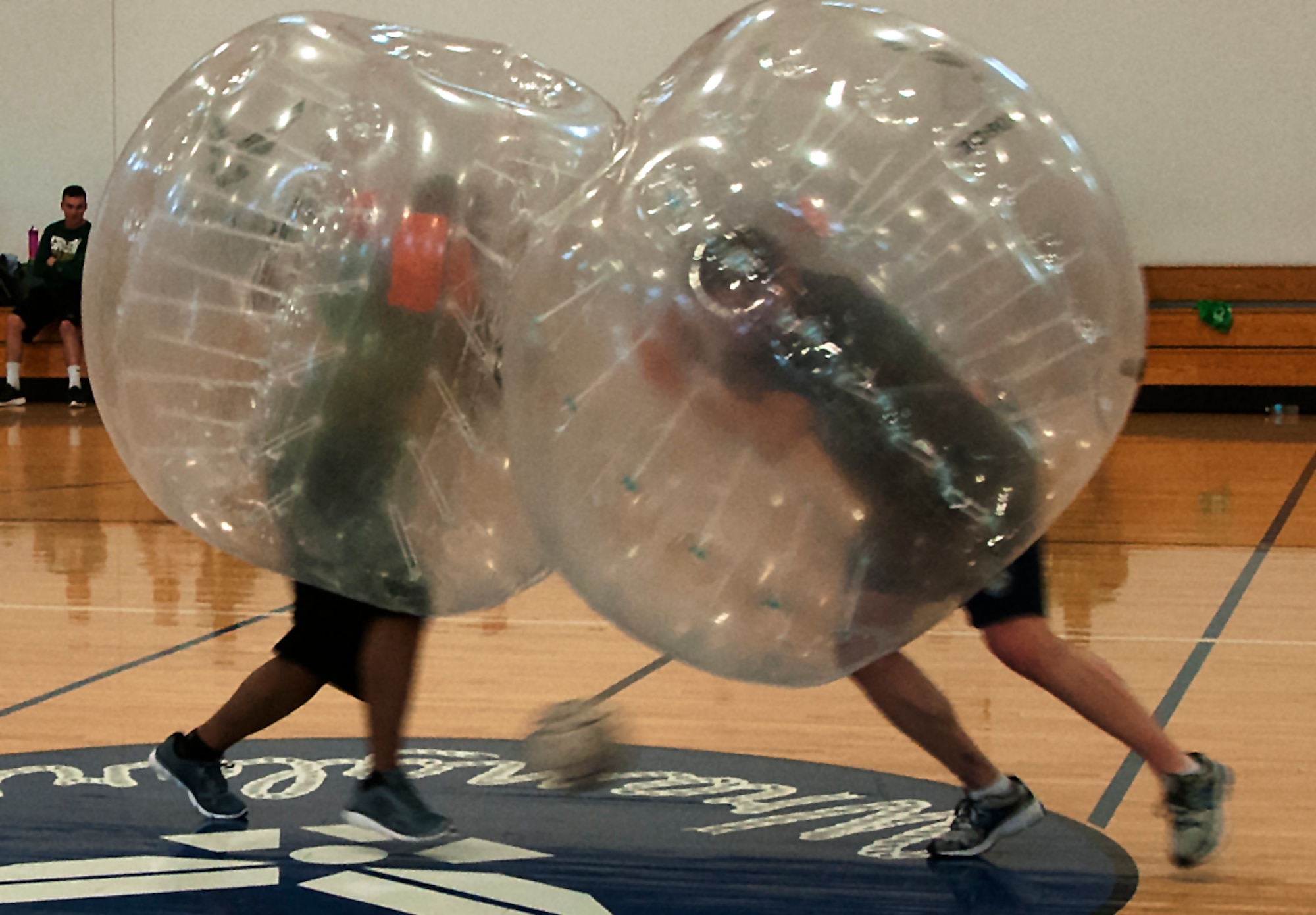 Two Airmen ram into one another during a bubble soccer game April 22, 2016, during a tournament inside the Freedom Hall Fitness Center on F.E. Warren Air Force Base, Wyo. Though scoring a goal was the overall objective, utilizing the bubbles to push opponents out of the way helped score. (U.S. Air Force photo by Senior Airman Brandon Valle)