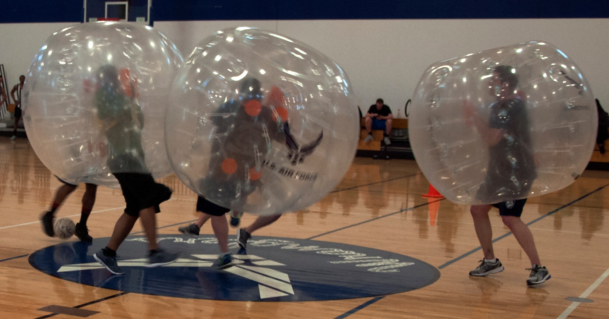 A group of Airmen collide during the start of a bubble soccer game April 22, 2016, during a tournament inside the Freedom Hall Fitness Center on F.E. Warren Air Force Base, Wyo. Teamwork was key as teams tried to score goals while remaining upright. (U.S. Air Force photo by Senior Airman Brandon Valle) 