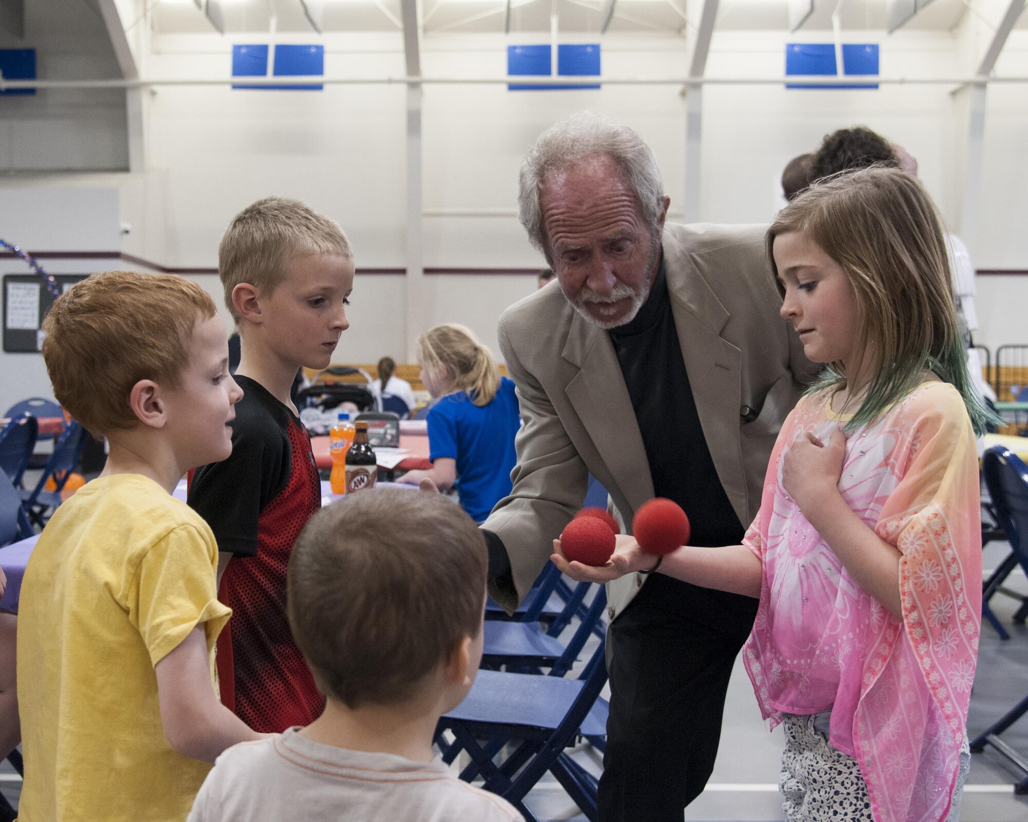 Lloydini, a magician, performs a magic trick for the children of Tech. Sgt. Brandon Layton, 790th Missile Security Forces Squadron Tactical Response Force, during the 90th Force Support Squadron Youth Center's Month of the Military Child Bash April 22, 2016, on F.E. Warren Air Force Base, Wyo. Lloydini and other entertainers took part in the event held by FSS personnel in celebration of the national Month of the Military Child. (U.S. Air Force photo by Senior Airman Jason Wiese)