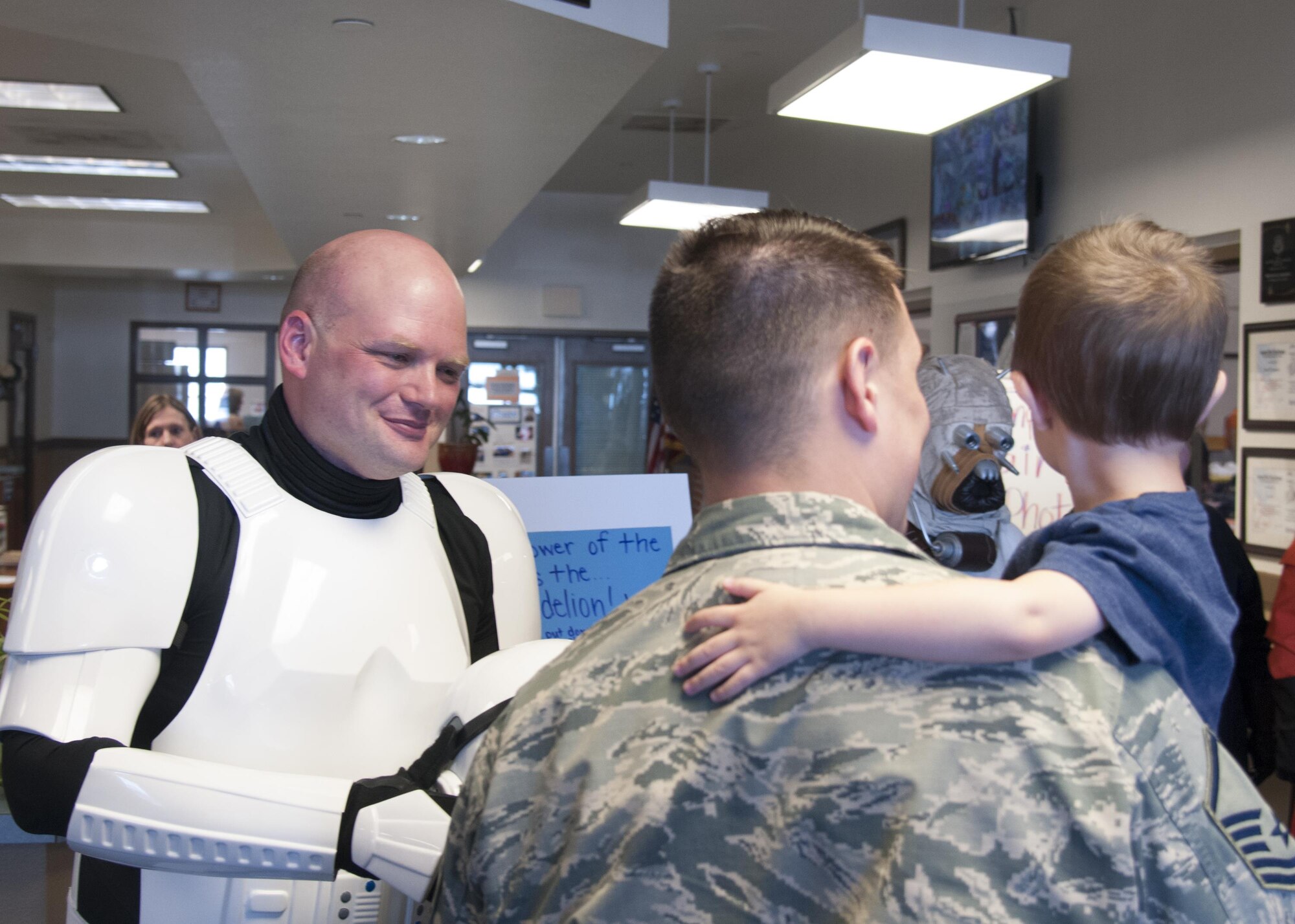 Technical Sgt. Jeffery Clemens, 90th Missile Maintenance Squadron Survivable Systems Team noncommissioned officer-in-charge, takes off his helmet while dressed as a science fiction character during the Month of the Military Child Bash in the Youth Center on F.E. Warren Air Force Base, Wyo., April 22, 2016. Several people dressed as various characters interacted with the children at the bash, which celebrated the national Month of the Military Child. (U.S. Air Force photo by Senior Airman Jason Wiese)