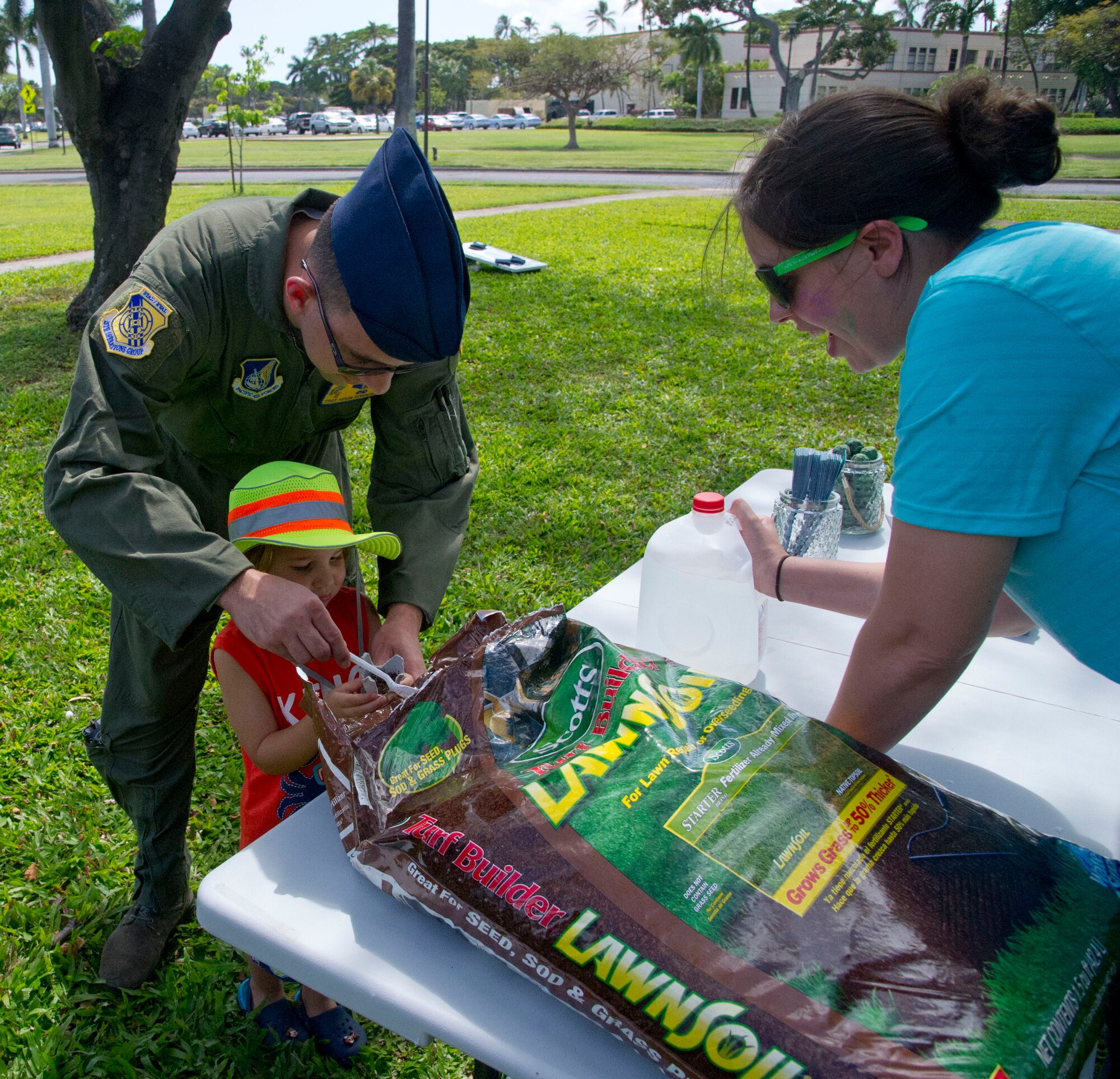 Tech. Sgt. Kevin Rondeau, 15th Operations Group, assists son Jax Rondeau, 3, with putting soil in a planting pot during the Plant for a Change Sexual Assault Awareness Prevention Month event on Joint Base Pearl Harbor-Hickam, Hawaii, April 22, 2016. (U.S. Air Force photo by Tech. Sgt. Terri Paden/Released)