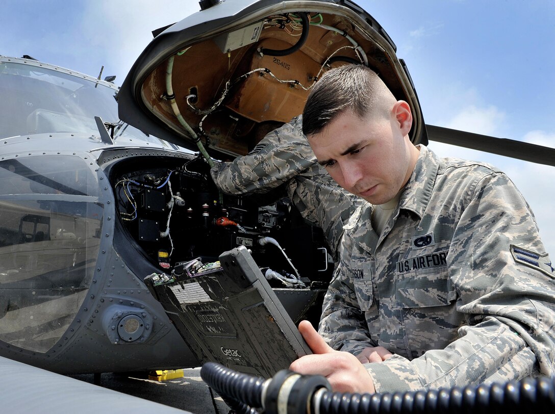 U.S. Air Force Airman 1st Class Ian Wilkerson, 718th Aircraft Maintenance Squadron communication navigation specialist, checks technical orders during a pre-flight inspection, April 26, 2016, at Kadena Air Base, Japan. The HH-60G Pave Hawk is maintained by Airmen with various specialties that include communications, navigations, engines, hydraulics, electronics, weapons systems and electronic counter warfare. (U.S. Air Force photo by Naoto Anazawa)
